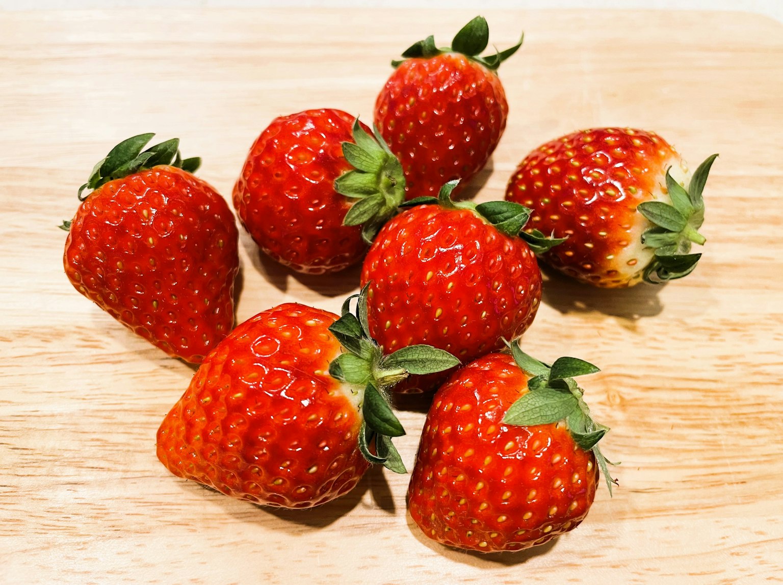 Fraises fraîches éparpillées sur une table en bois