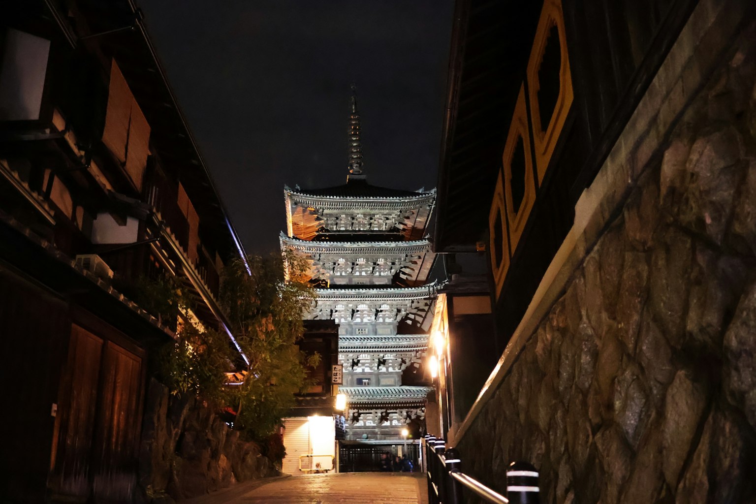 Eine schöne Pagode, die über eine nächtliche Straße mit traditionellen Gebäuden ragt