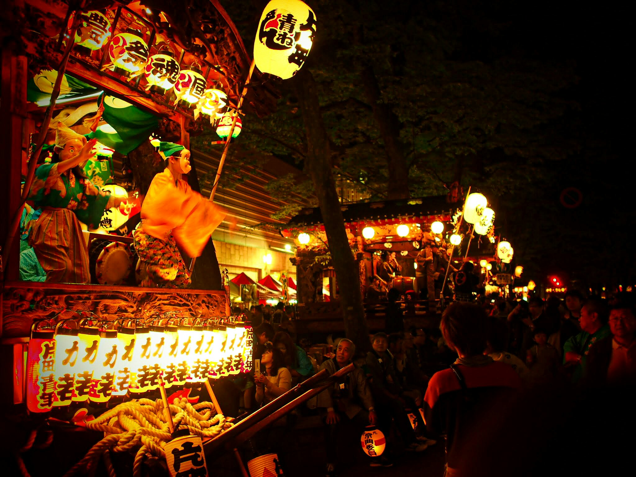 提灯と屋台が並ぶ夜の祭りの参道