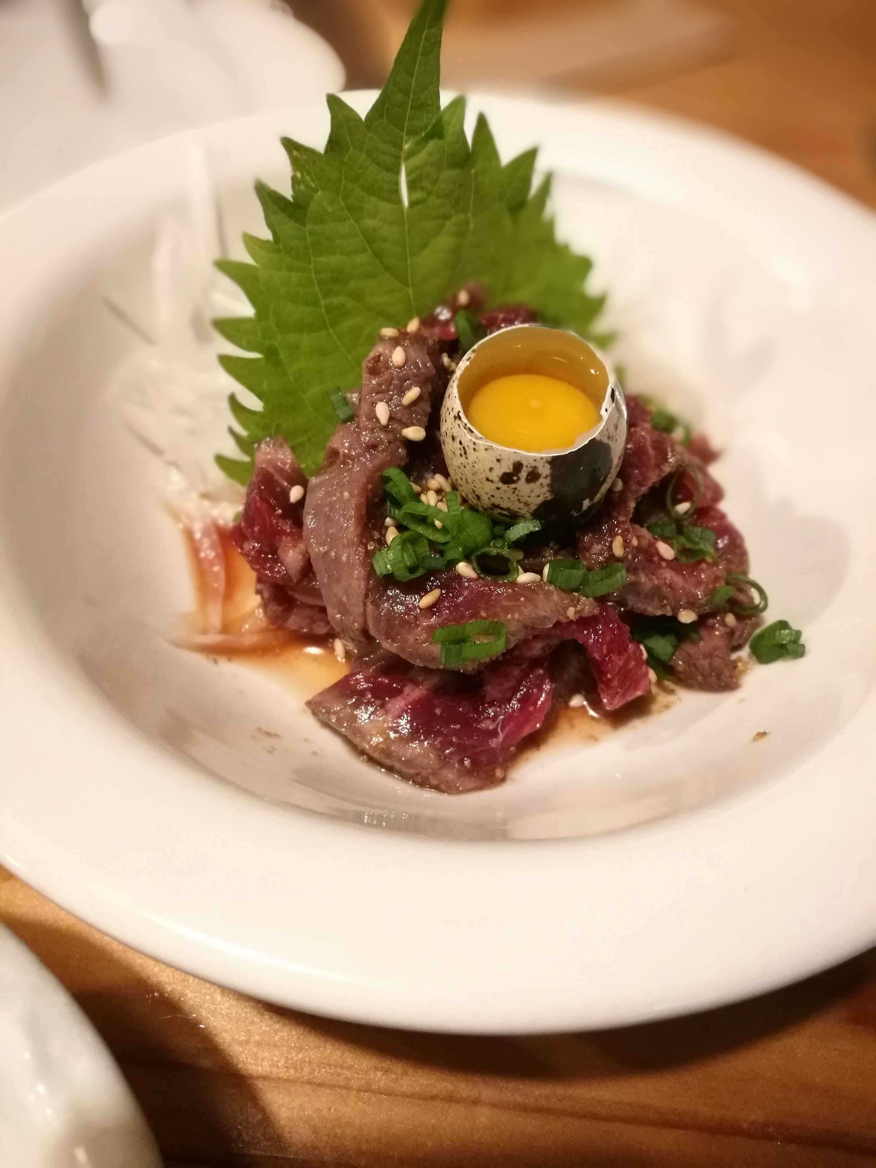搭配香草與葉片裝飾的生肉拼盤圖片