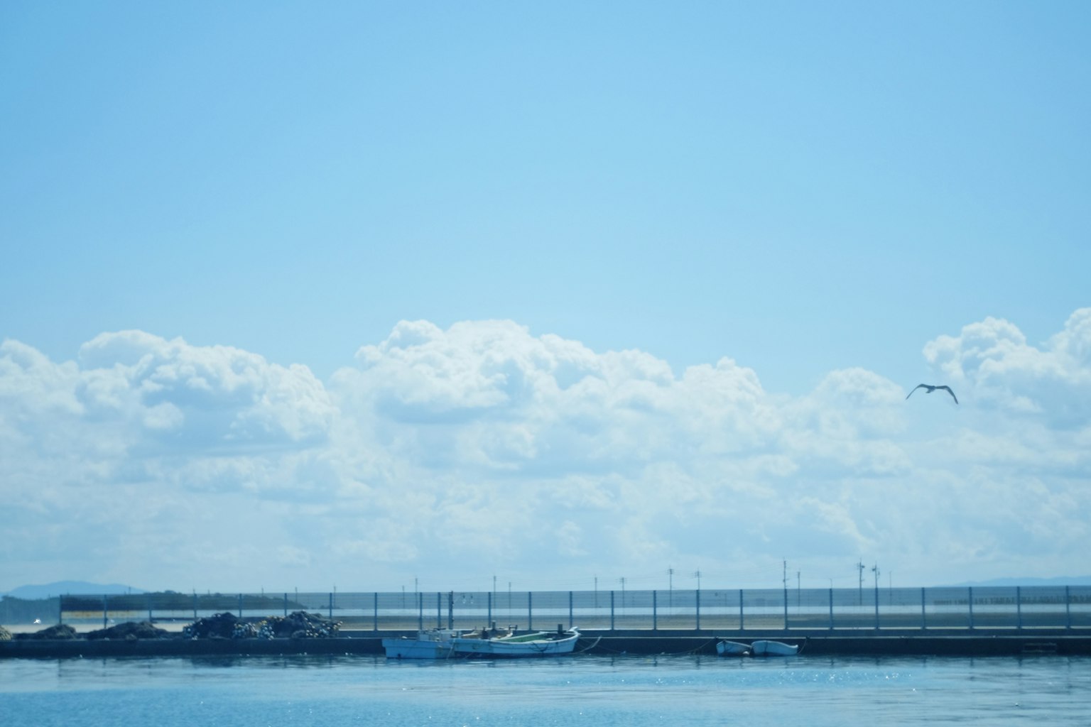宁静的海景，小船在蓝天和云朵下