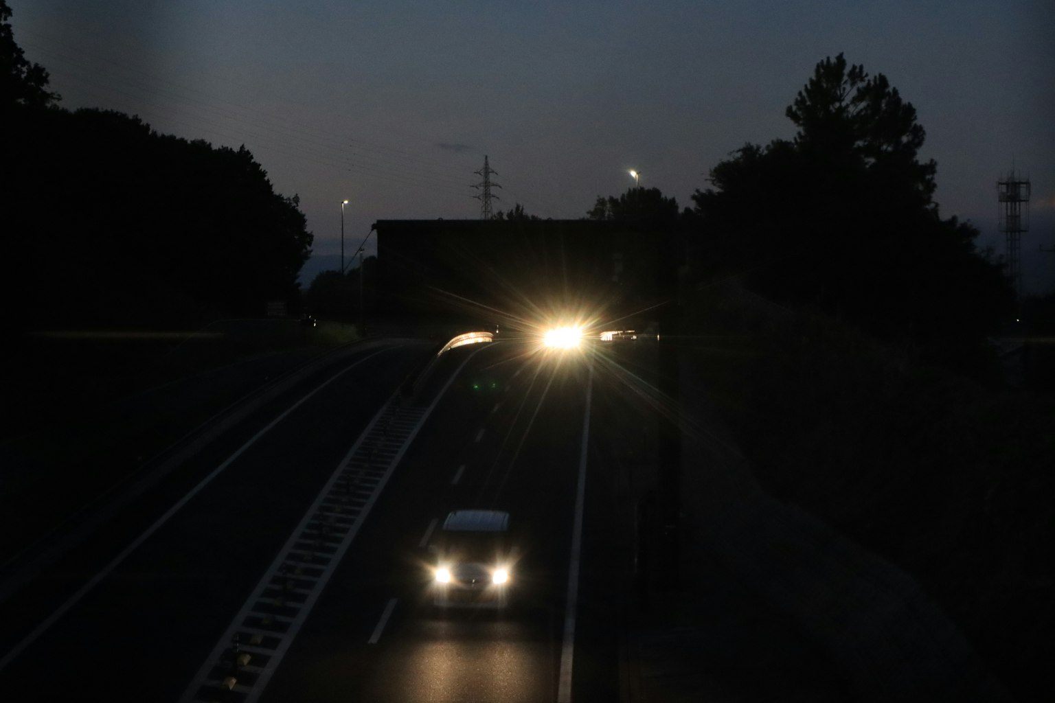 夜間行駛的汽車在路上，車頭燈亮著