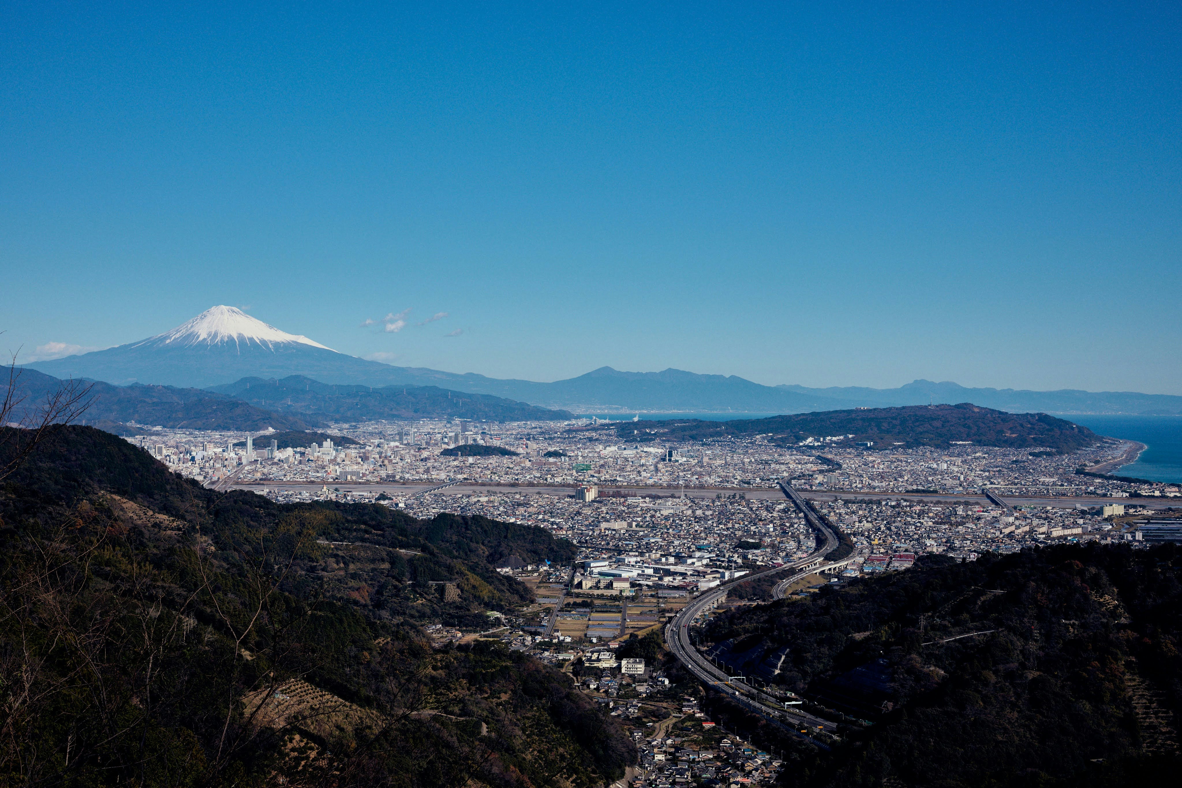 從山稜俯瞰的城市景觀與遠處富士山