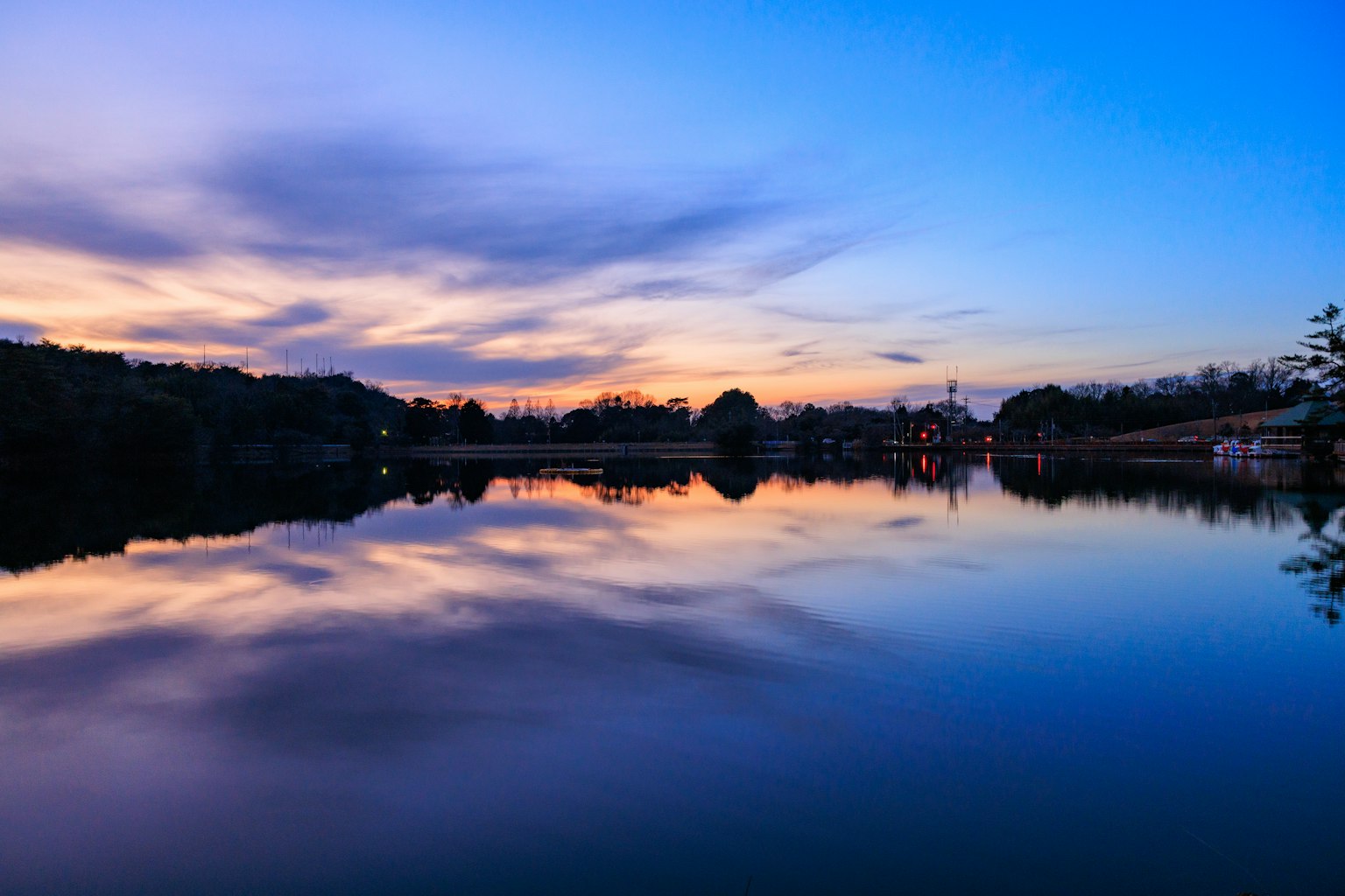 ทะเลสาบเงียบสงบในยามพระอาทิตย์ตกพร้อมการสะท้อนที่สวยงาม