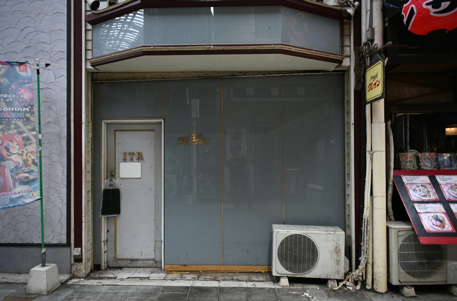 灰色商店外立面，带有门和空调