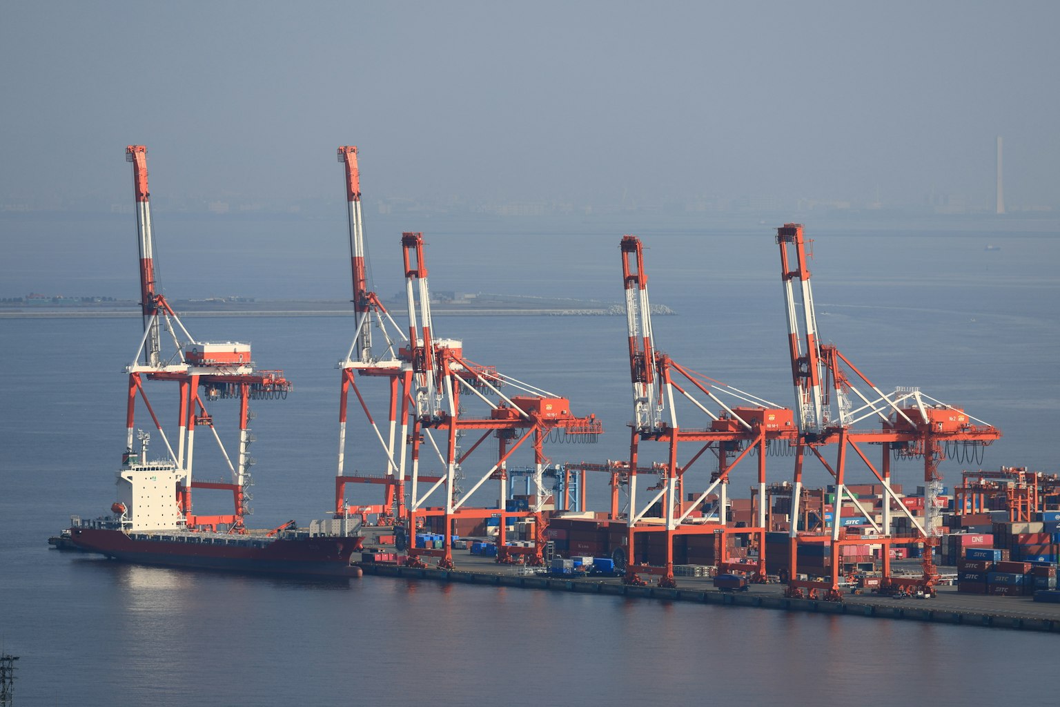 Frachtschiff im Hafen mit Kränen im Hintergrund