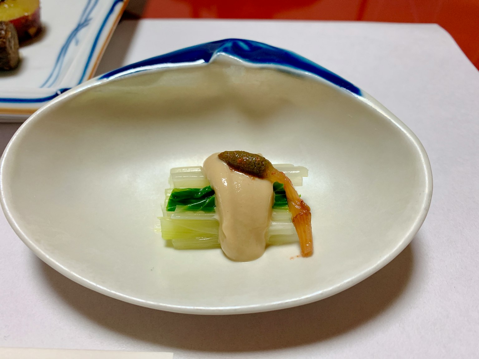 Piatto servito su un piatto bianco con verdure verdi e salsa bianca