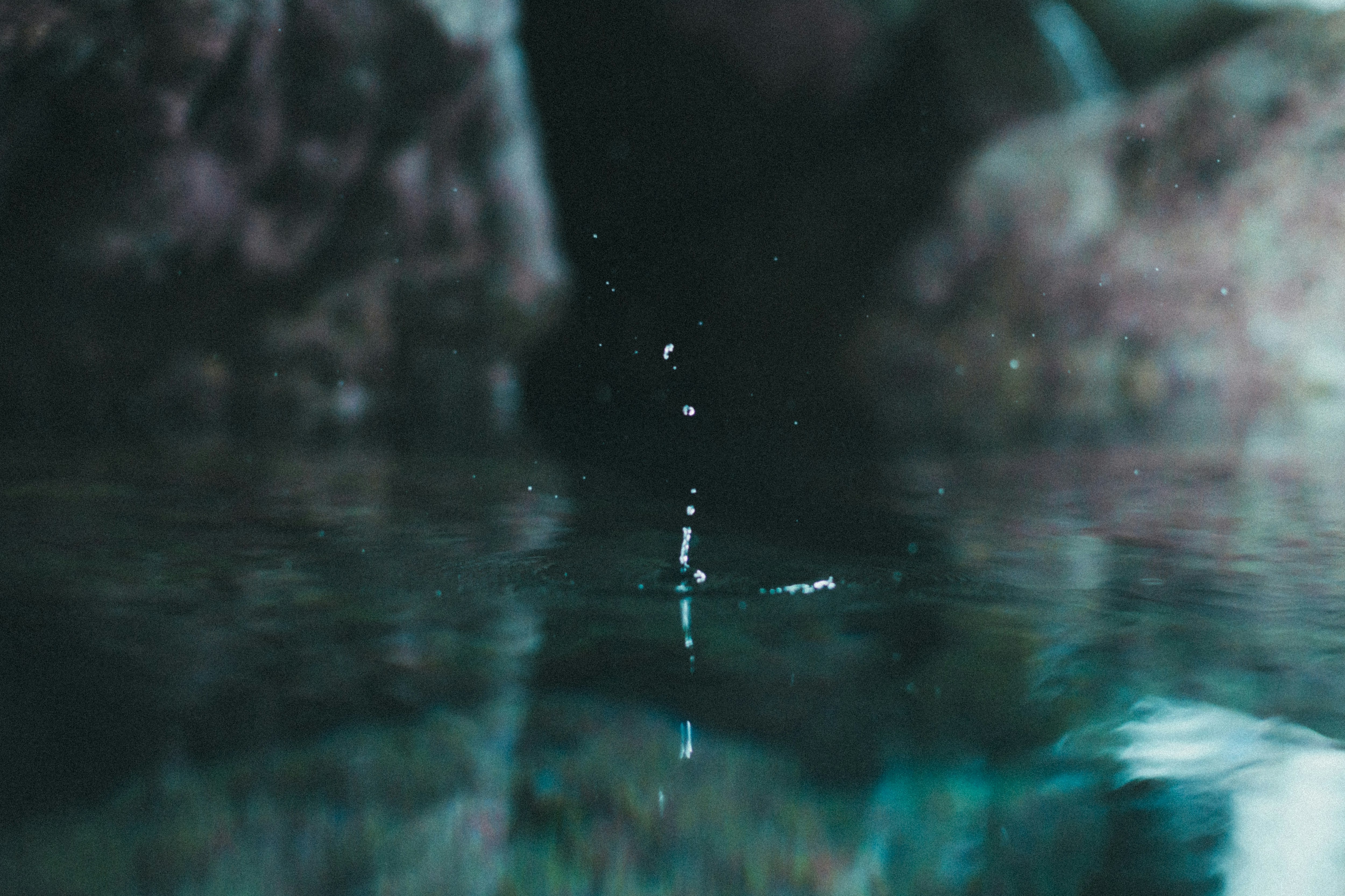 Water droplets splashing across a rippling surface