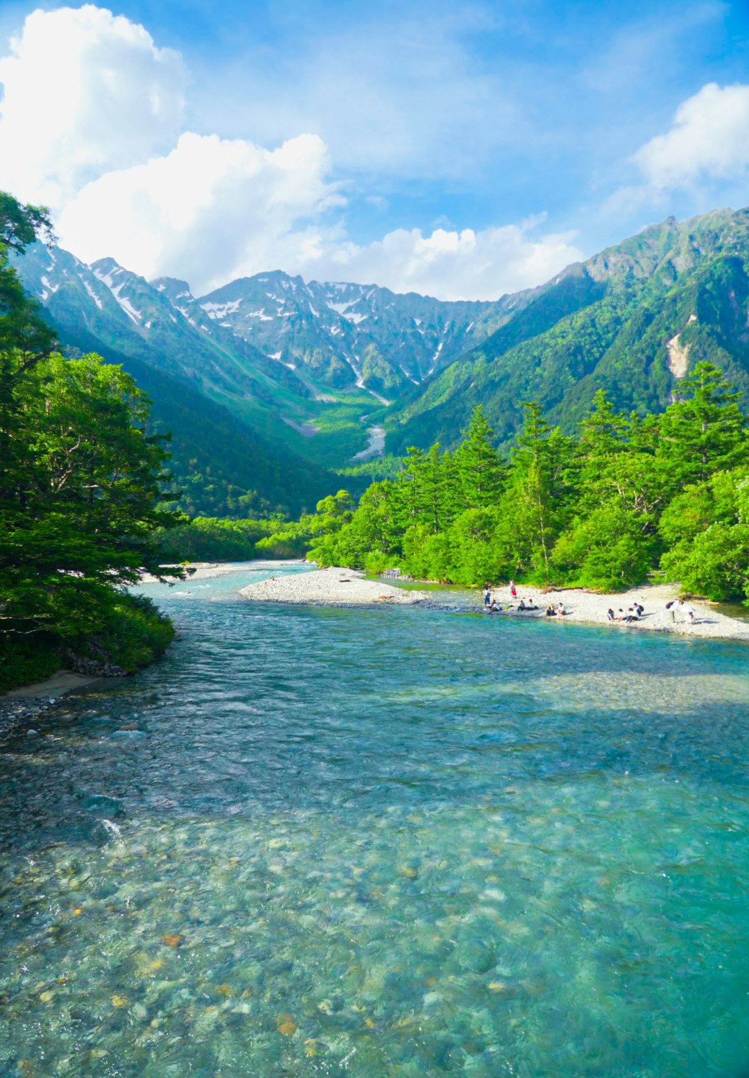 夏の上高地の澄んだ川と緑の山並み