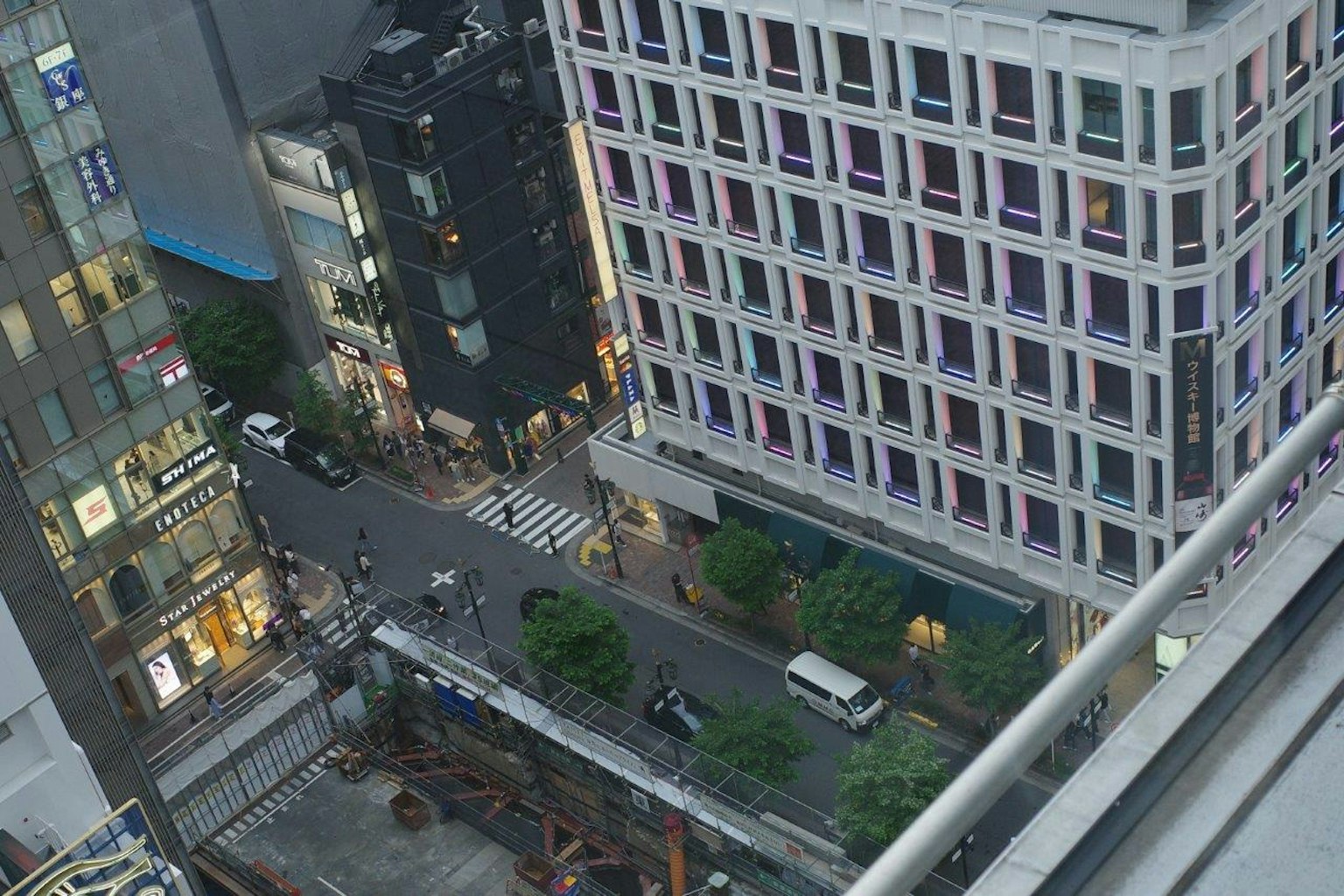 Aerial view of a city street with modern buildings and greenery