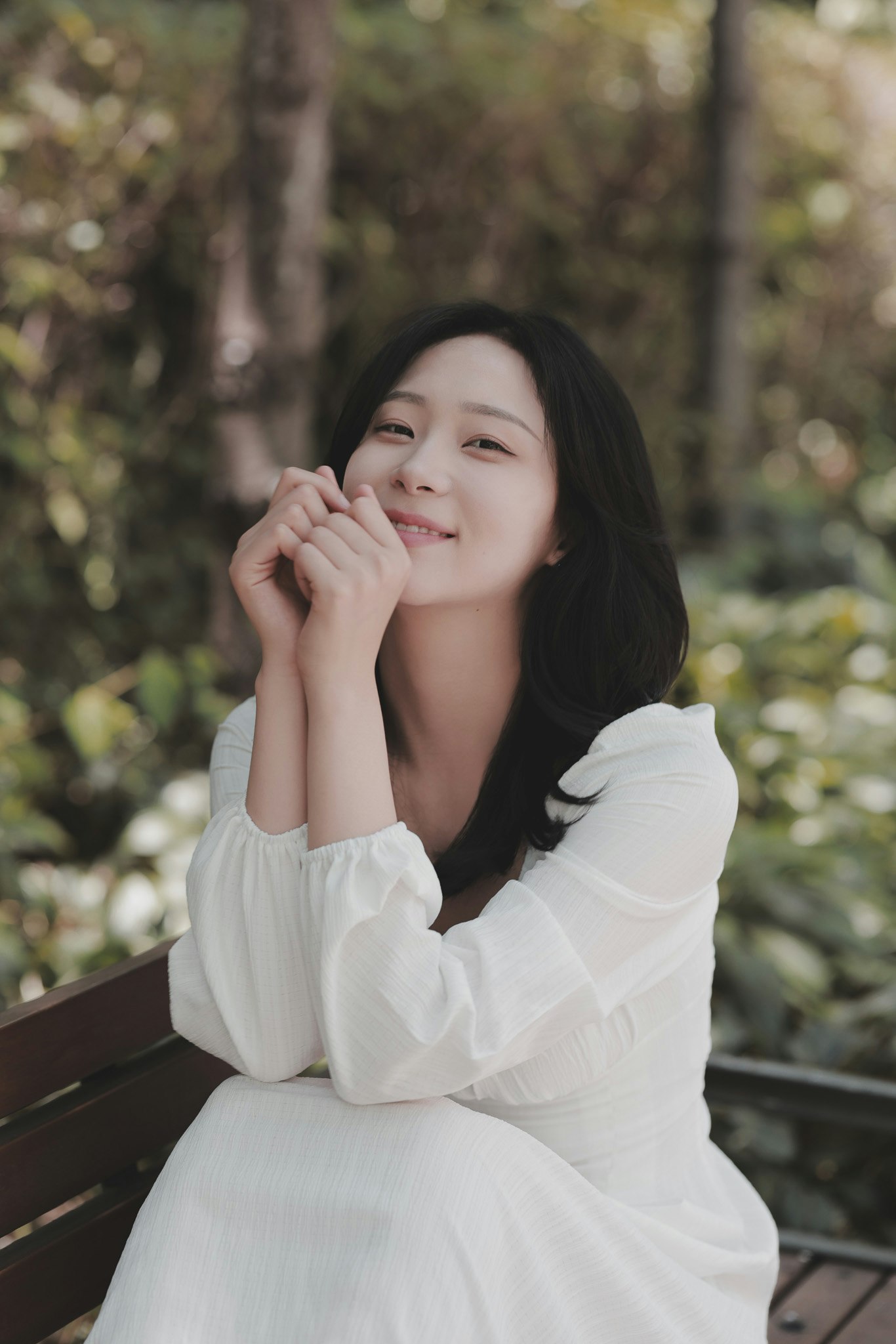 smiling woman sitting on a park bench