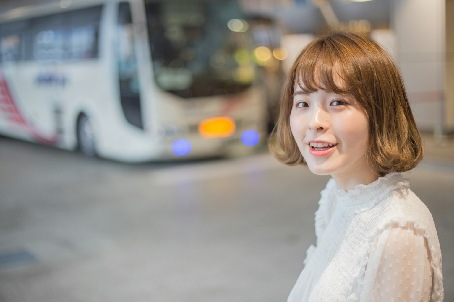 Retrato de una mujer sonriente con un autobús de fondo