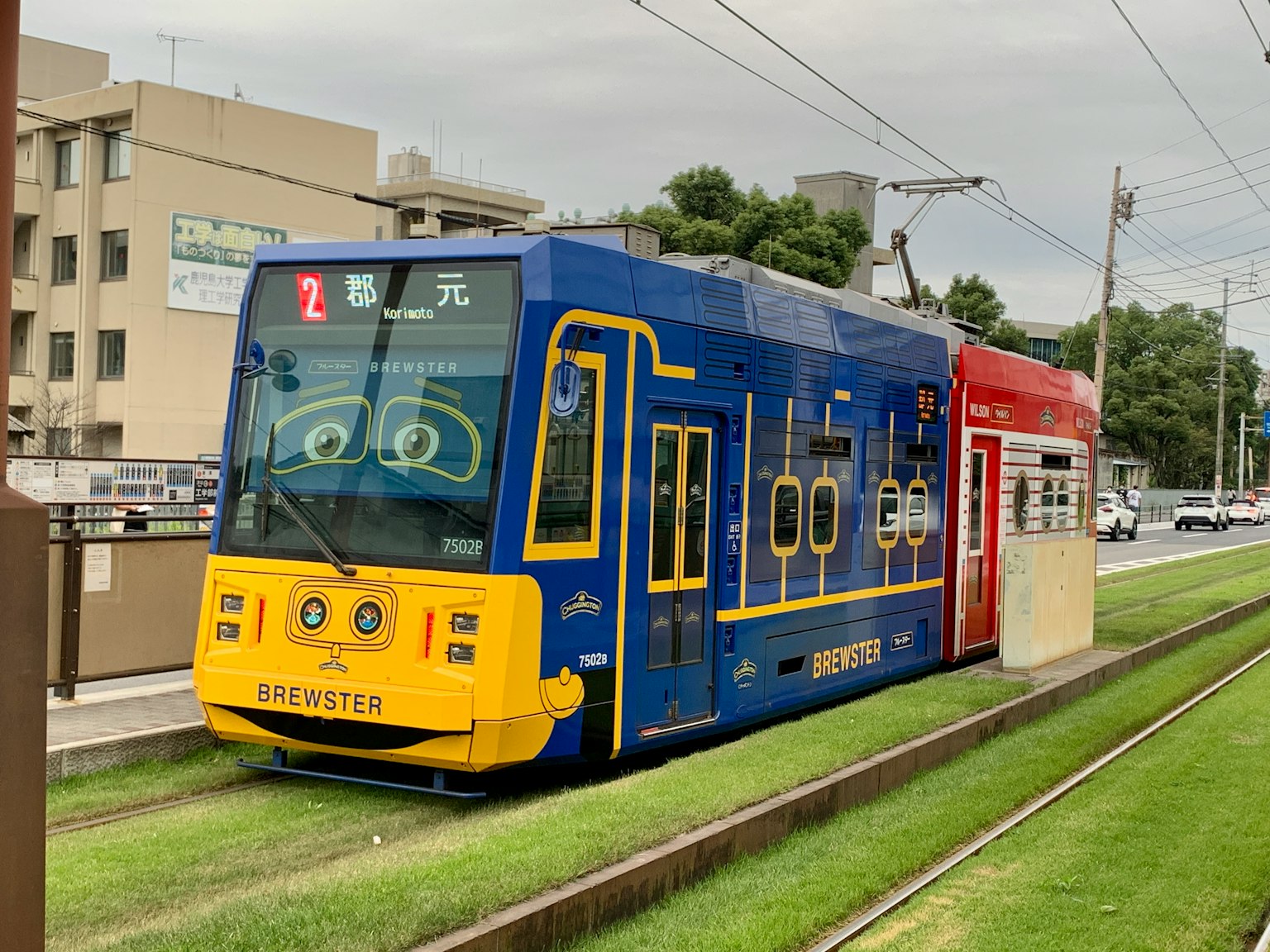 Un tramway bleu avec des motifs de dessin animé garé sur les rails