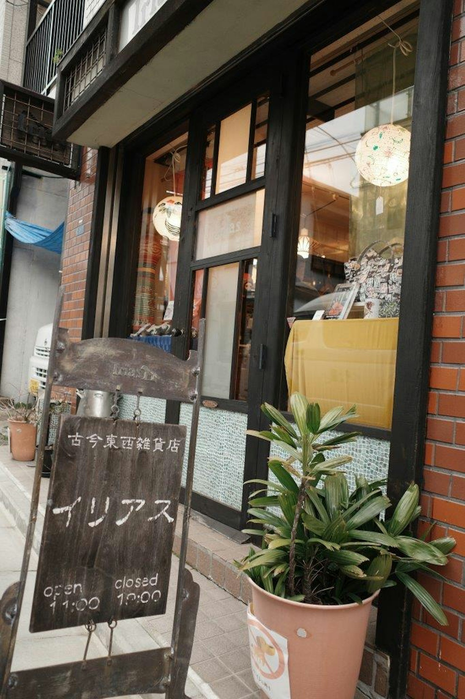 Pintu kafe dengan tanda yang terlihat dan tanaman