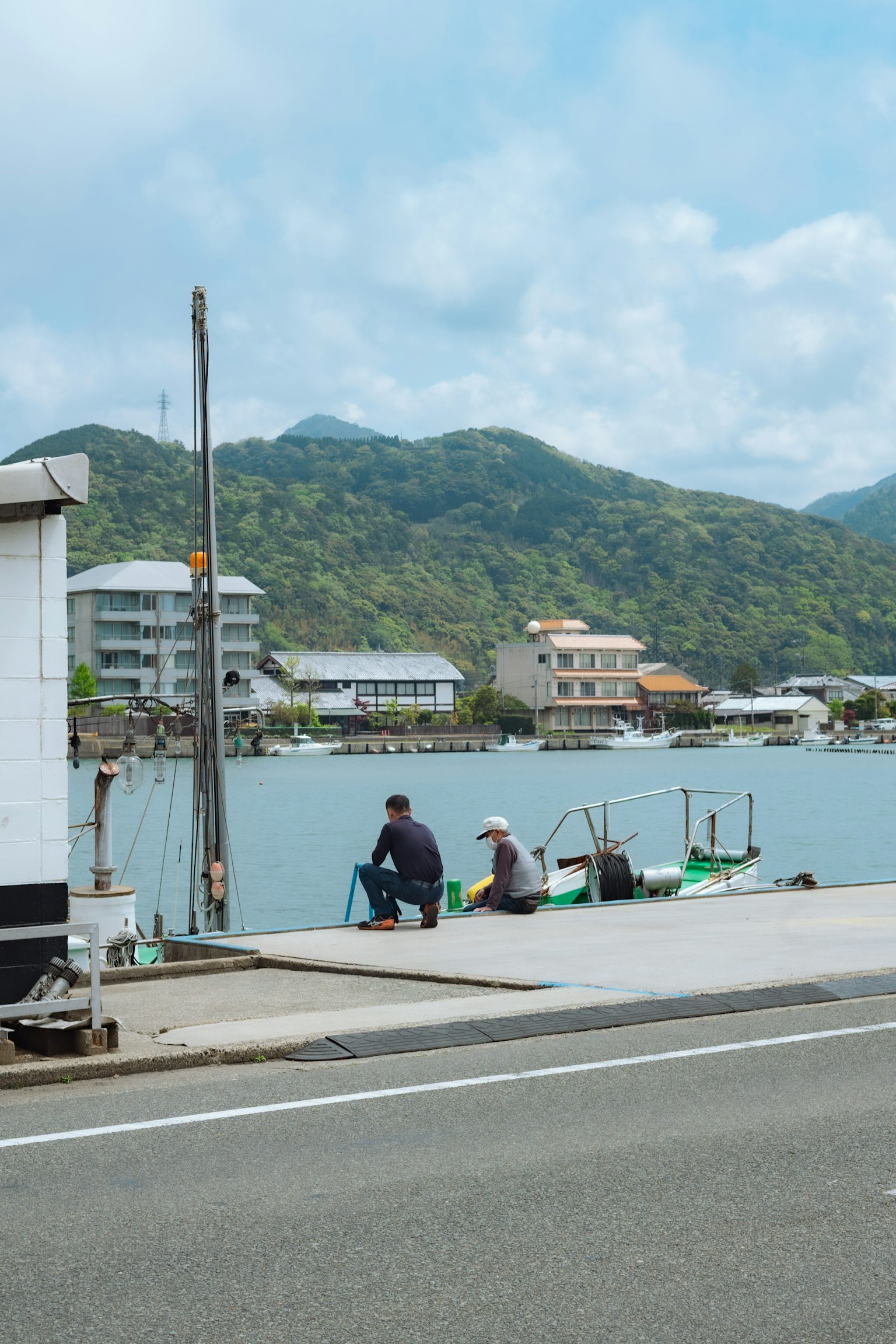 海辺で釣りをする二人の男性と静かな風景