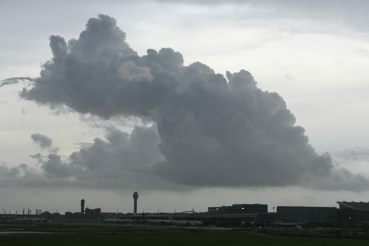 Un grand nuage gris surplombe un paysage d'aéroport
