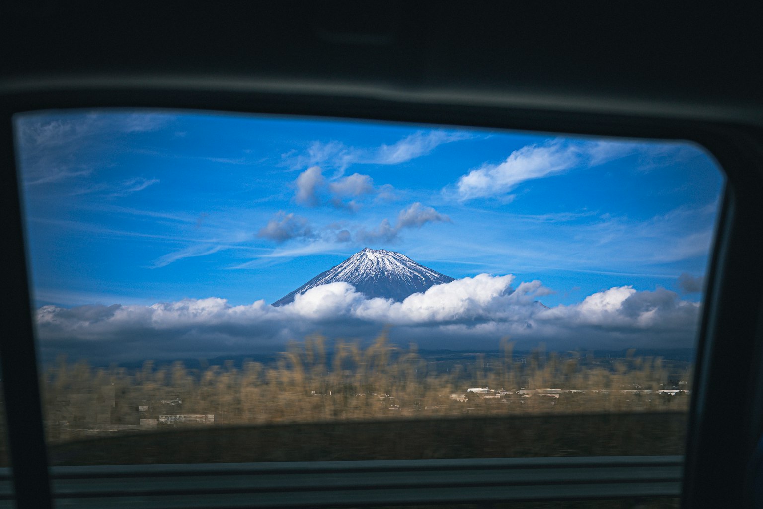 Mont enneigé vu à travers une fenêtre de voiture avec ciel bleu
