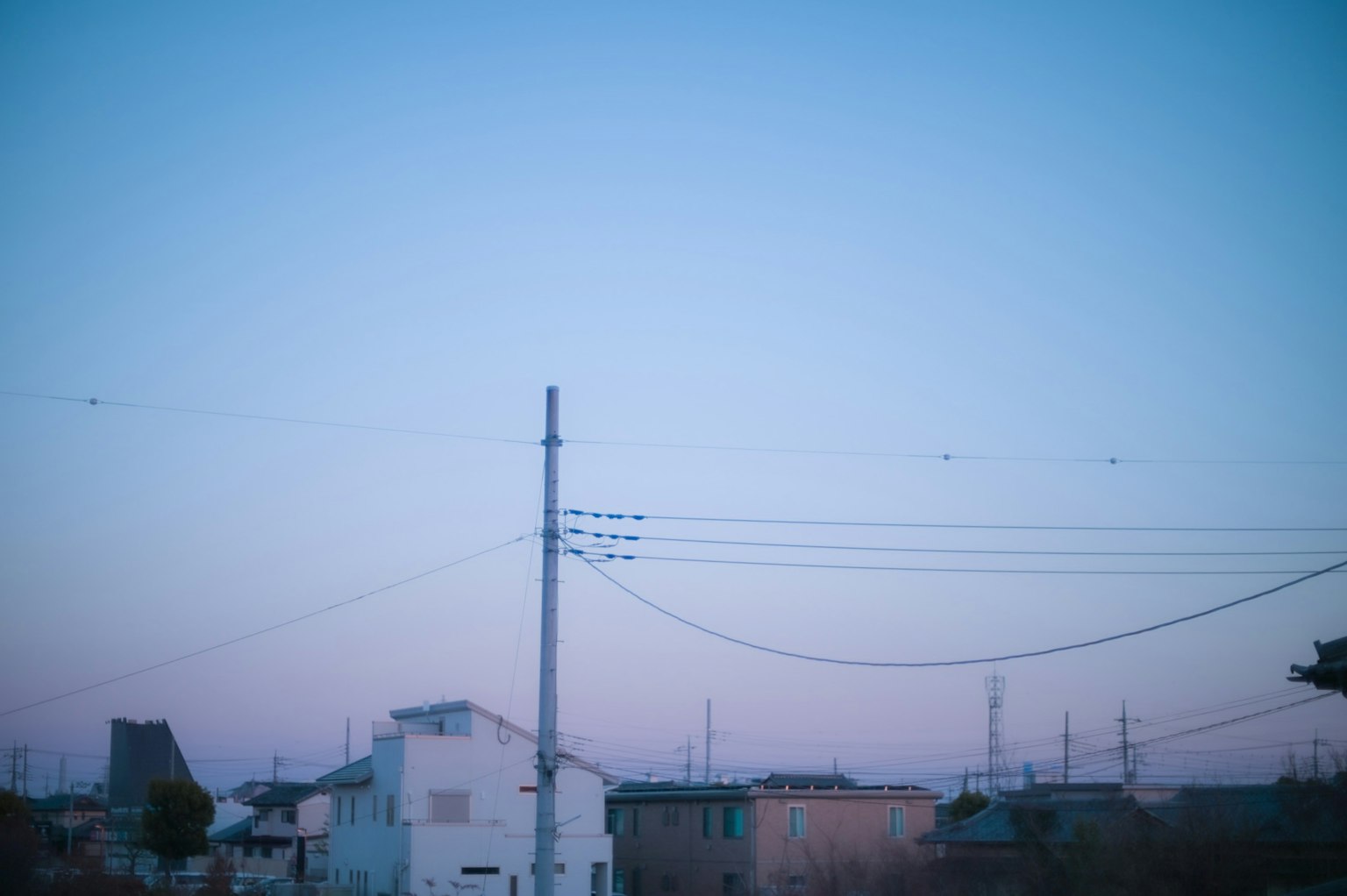 Paesaggio urbano sereno con cielo blu pallido e viola e linee elettriche