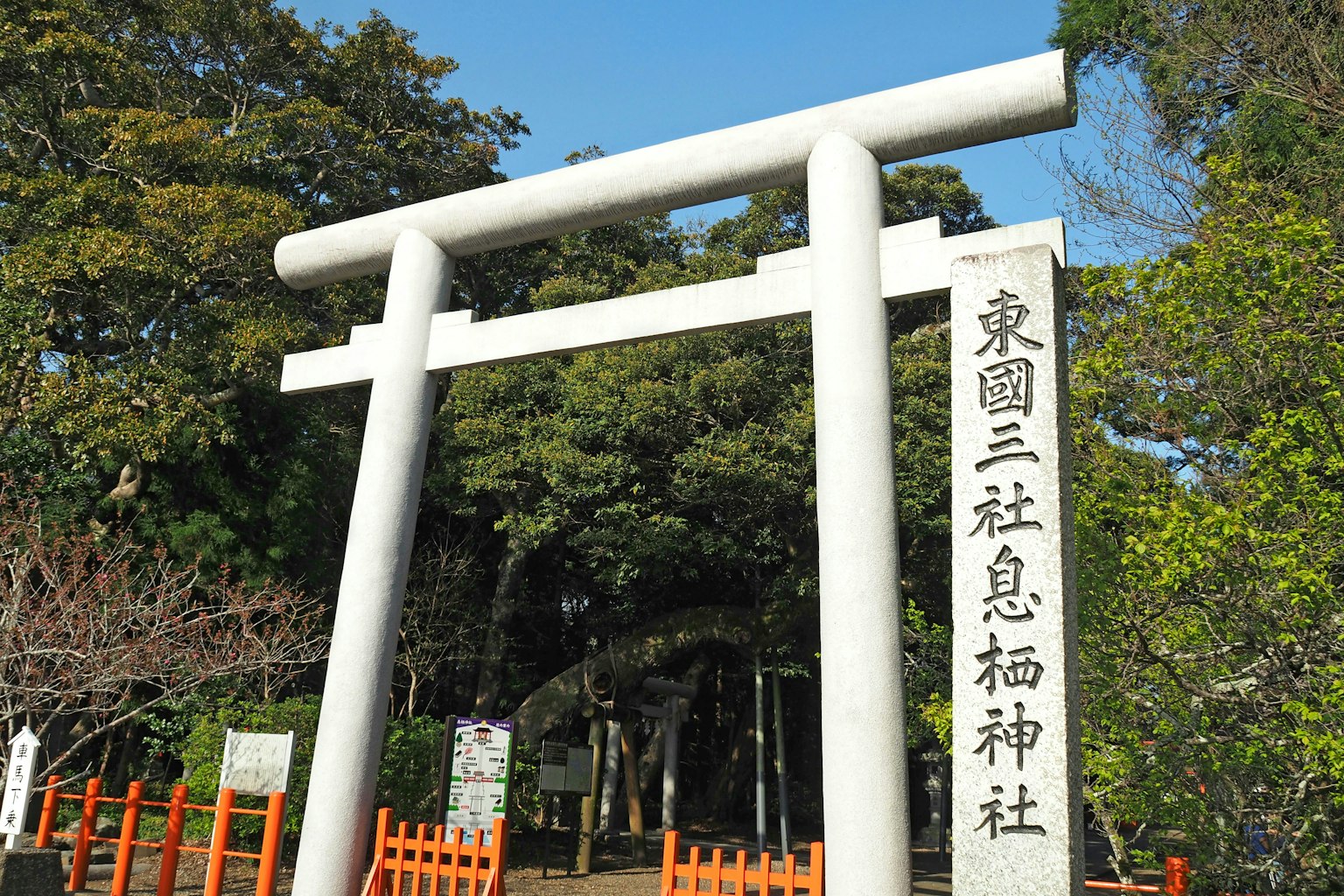 Puerta torii blanca con árboles verdes alrededor en el santuario Higashi-en San-sha Sume