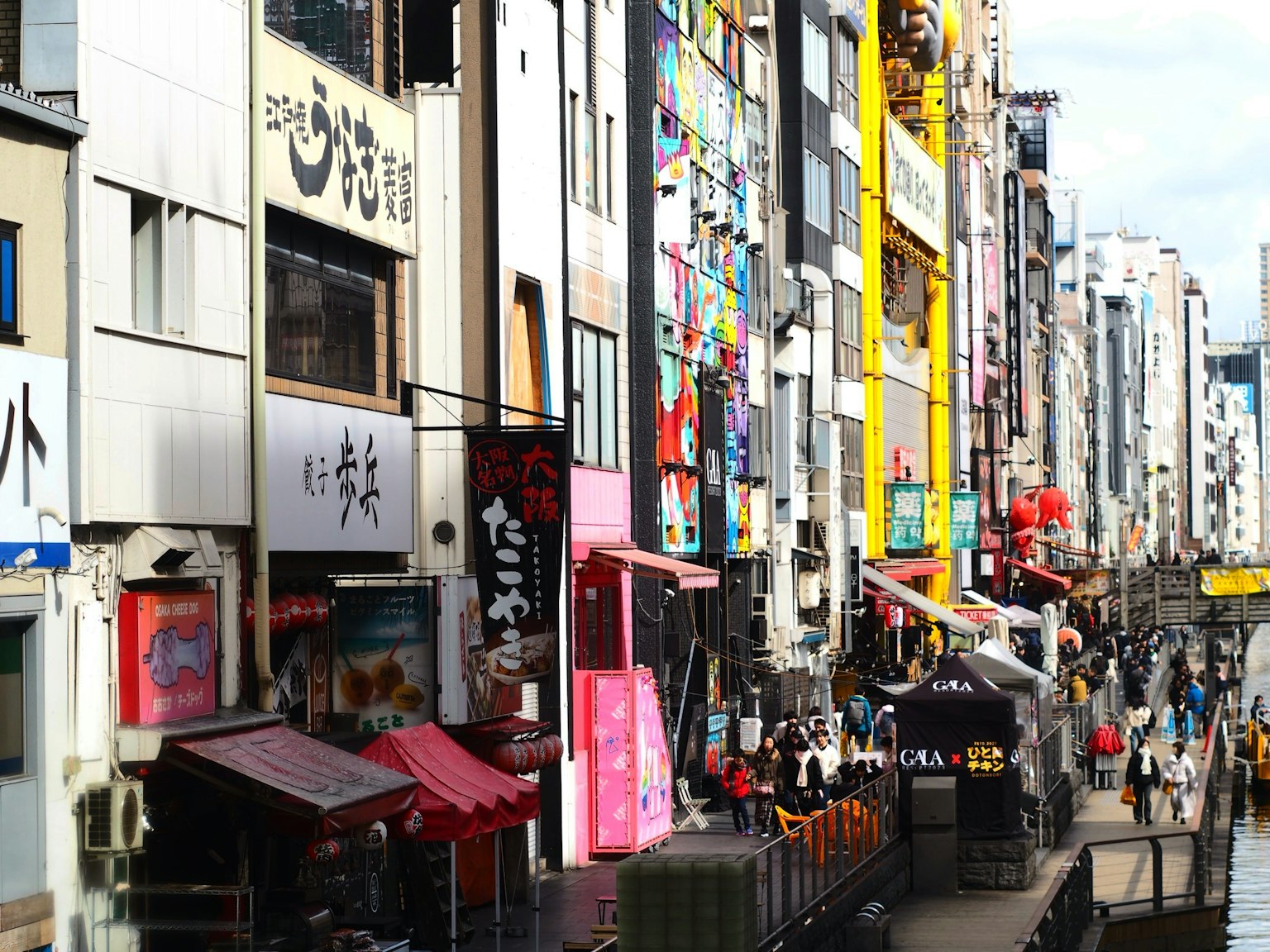 ทิวทัศน์ถนนที่มีชีวิตชีวาพร้อมป้ายสีสันสดใสในพื้นที่เมืองที่คึกคัก