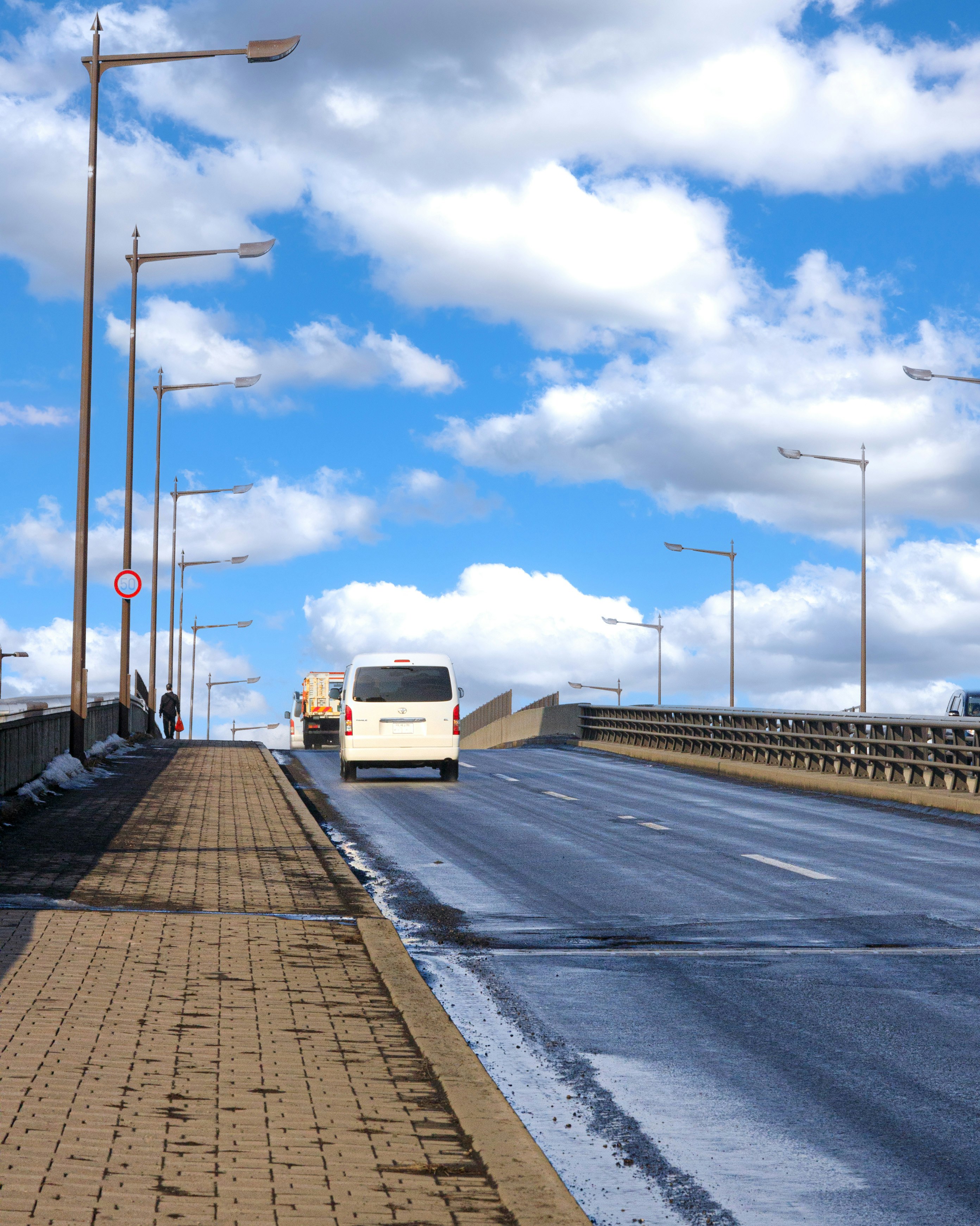 空へ続く青空の下の高速道路と歩道