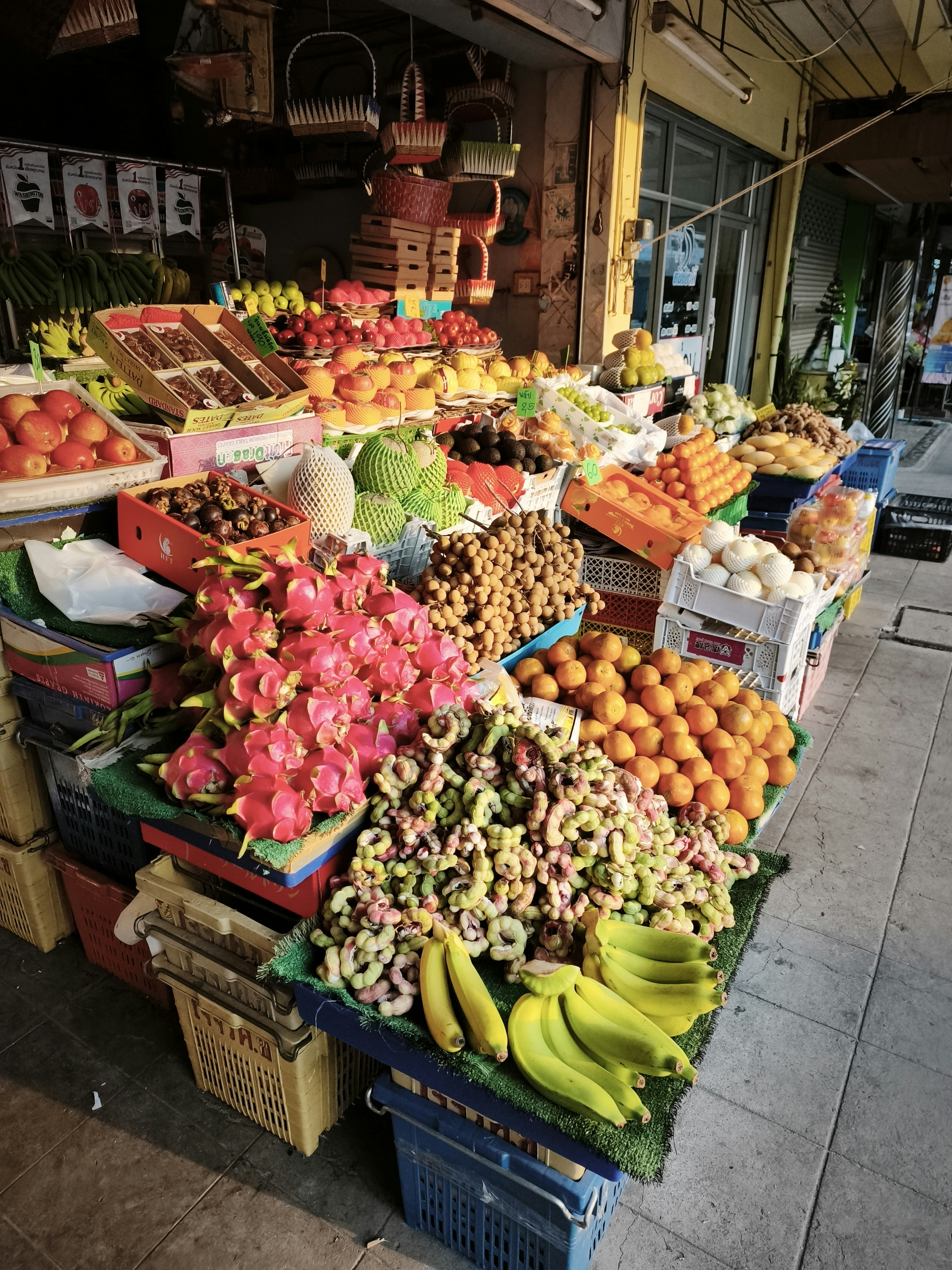 路地の青果店で並ぶ色とりどりの果物と野菜のショーケース