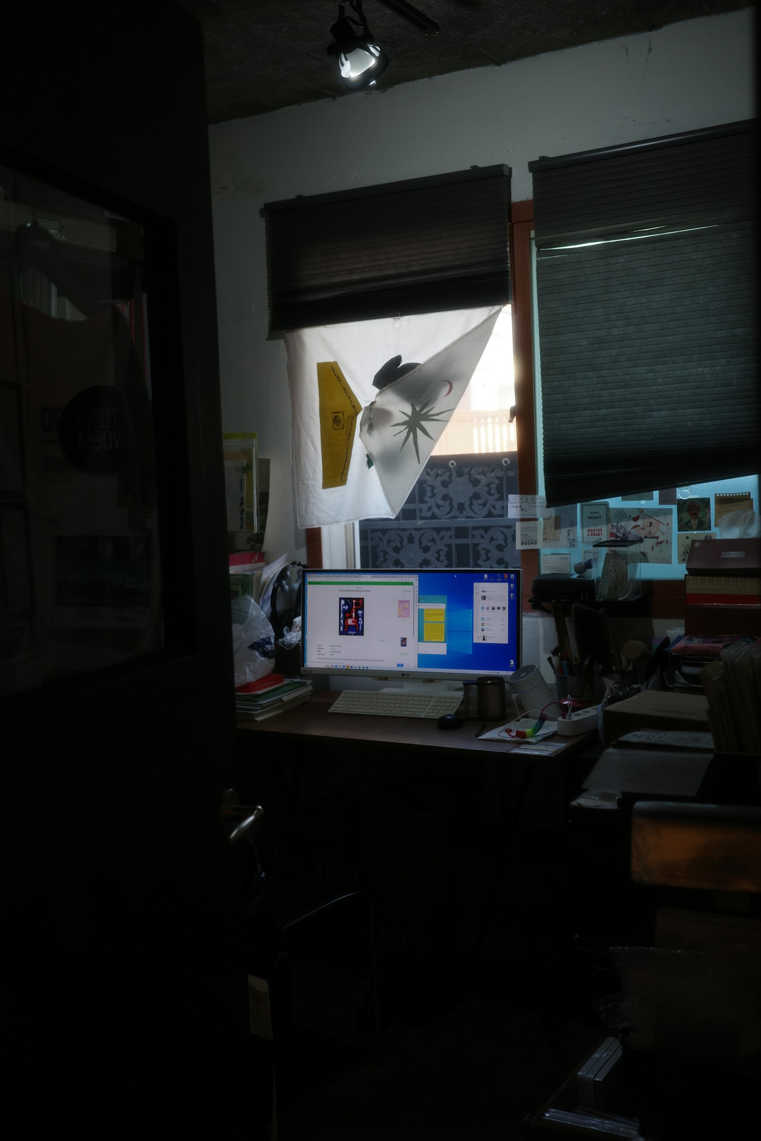 Chambre faiblement éclairée avec un bureau et un ordinateur Lumière passant par la fenêtre Espace de travail en désordre