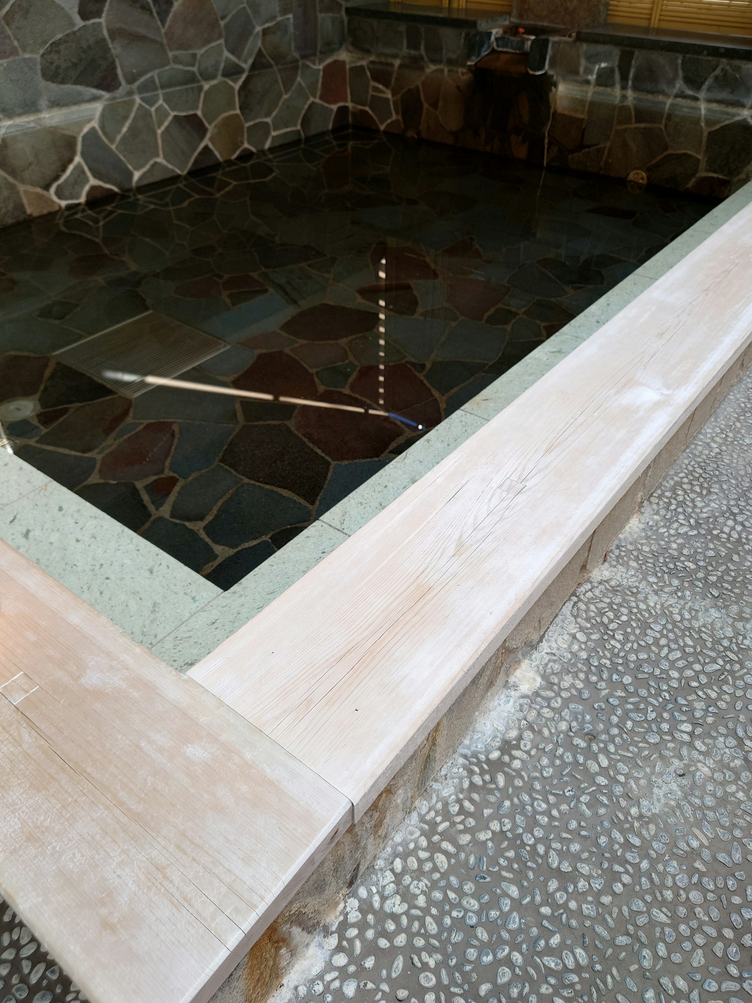 Vista interna di un bagno in pietra con superficie d'acqua riflettente