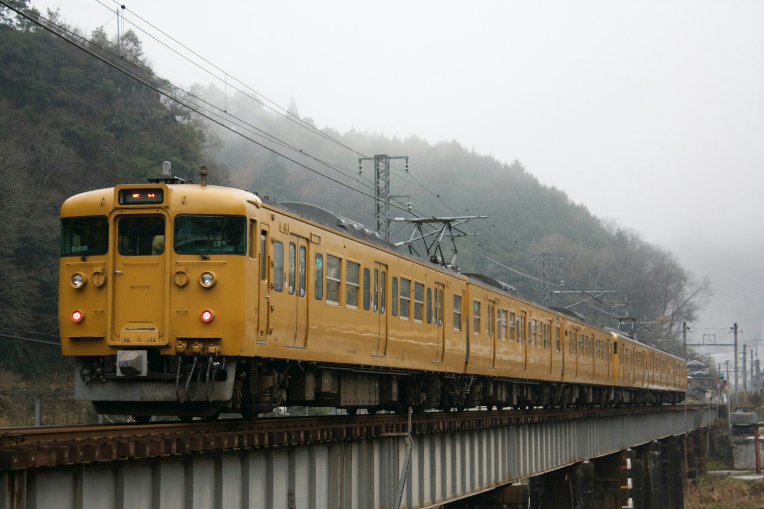 霧中穿越橋樑的黃色火車