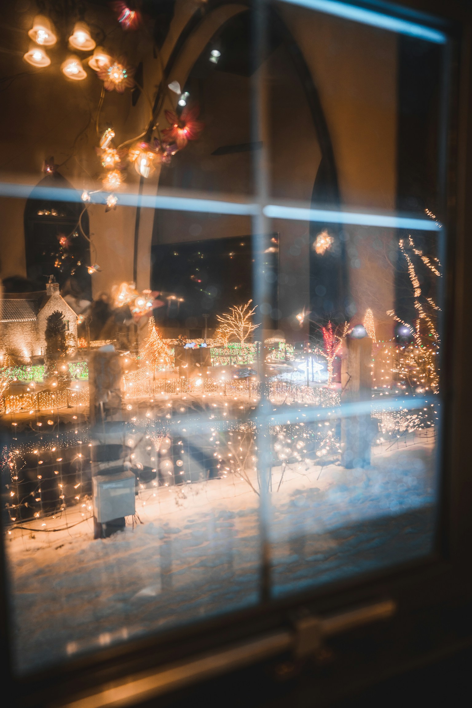 Scène nocturne d'hiver avec des lumières scintillantes vues à travers une fenêtre
