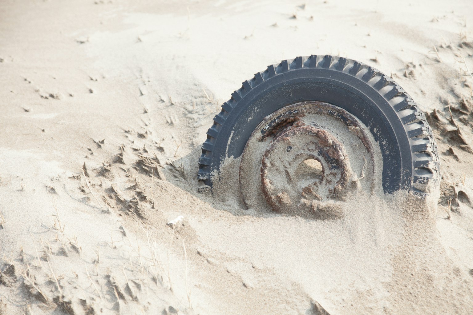 Partially buried tire in sand