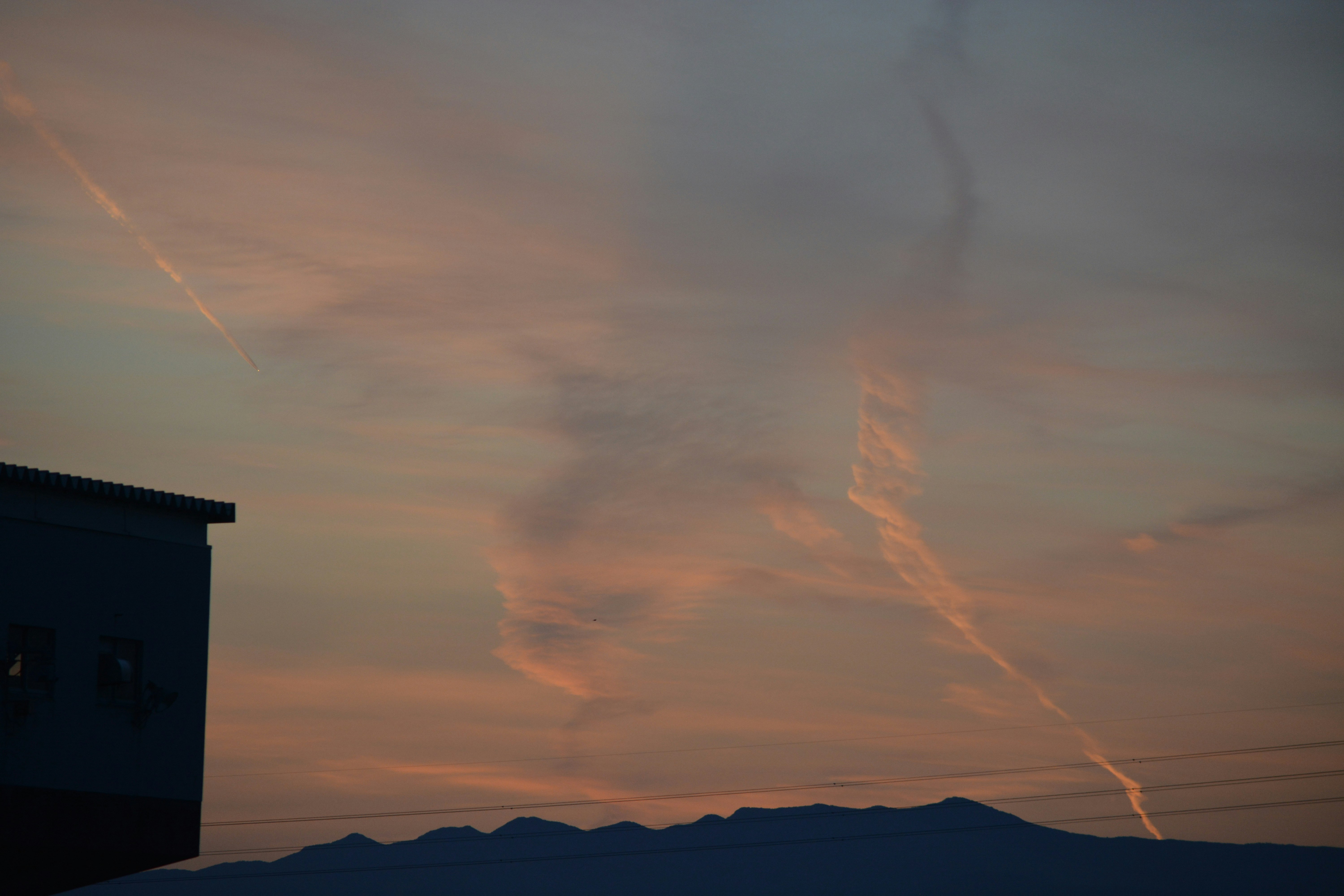 ciel de coucher de soleil avec nuages en traînées et silhouettes de montagnes