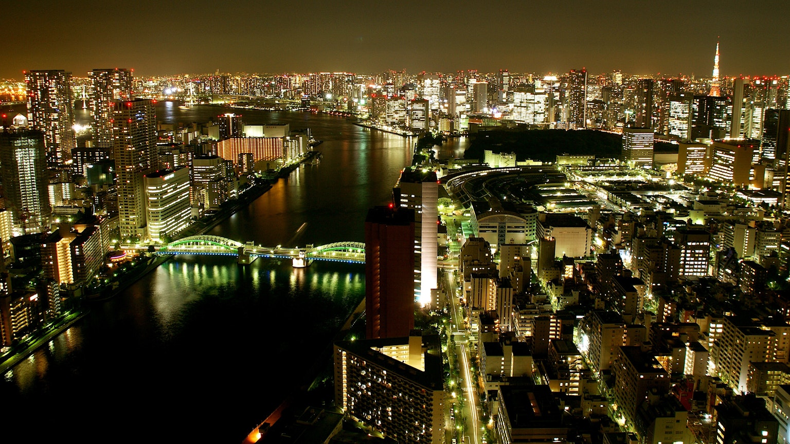 Tokyo skyline at night with illuminated buildings and a river view