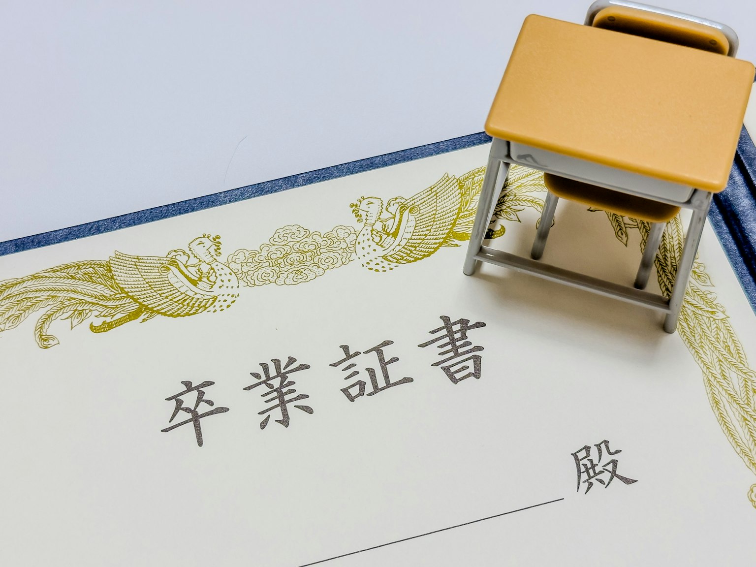 畢業證書的圖片，上面有日文文字和一個迷你書桌