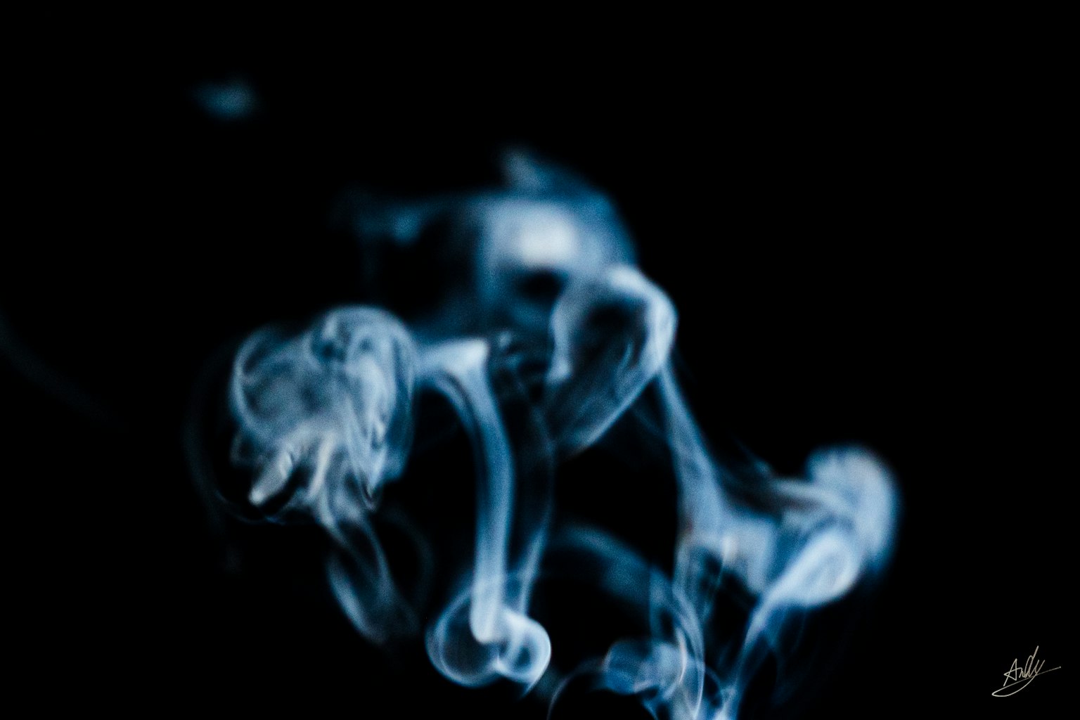 Ethereal blue smoke swirling against a black background