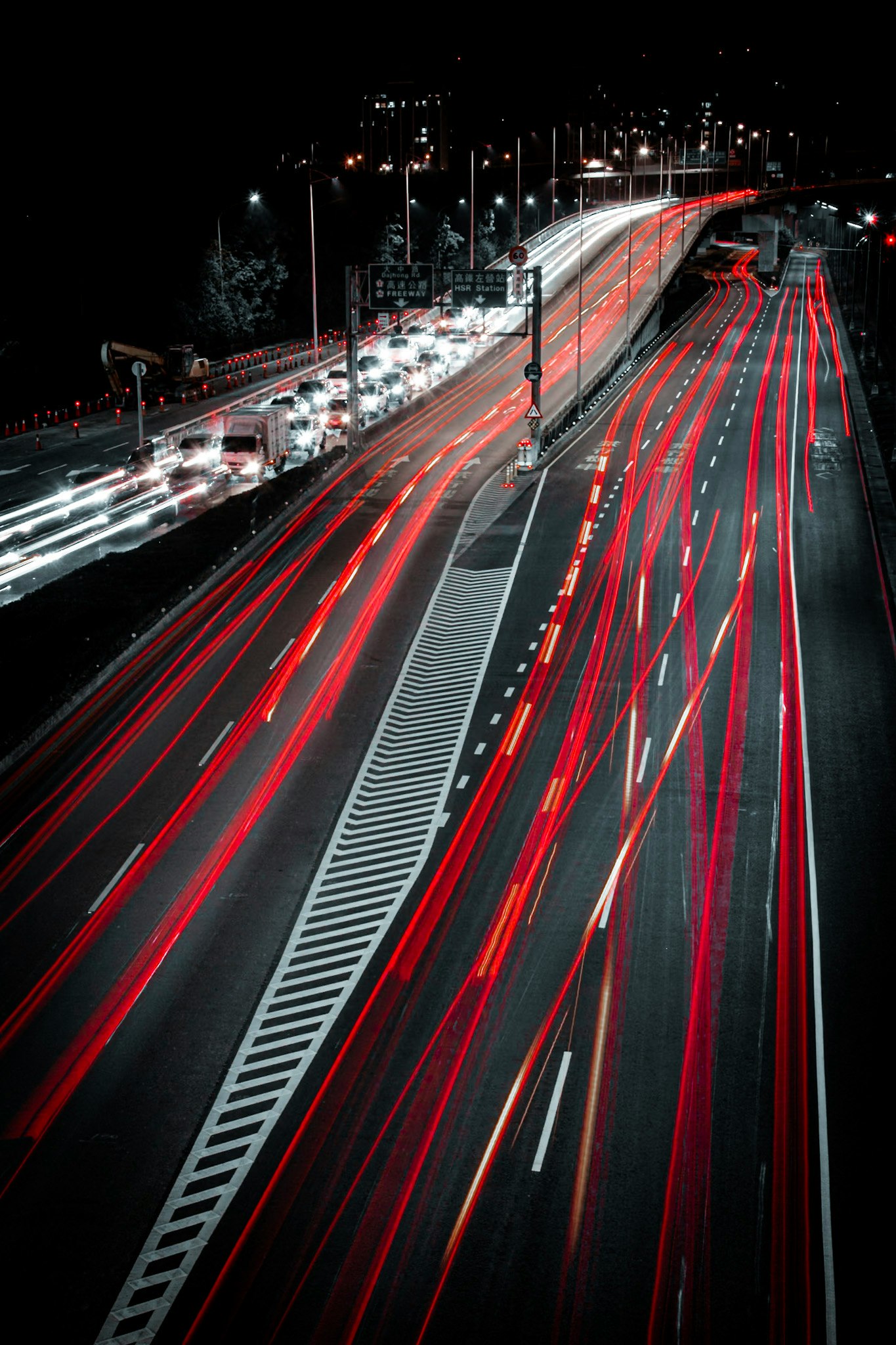 夜の高速道路を走る赤い光の軌跡