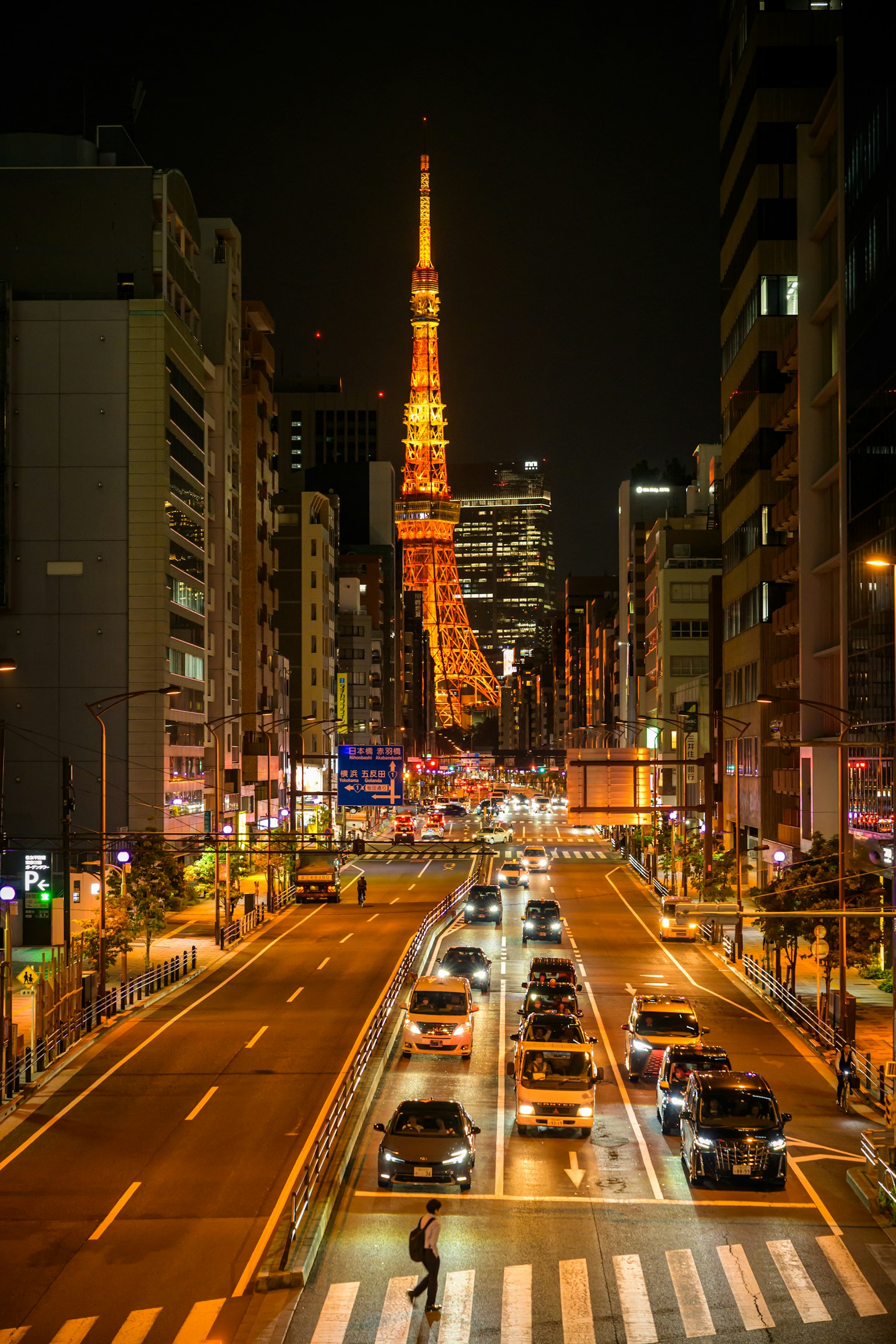 Torre di Tokyo illuminata di notte con strada trafficata e auto