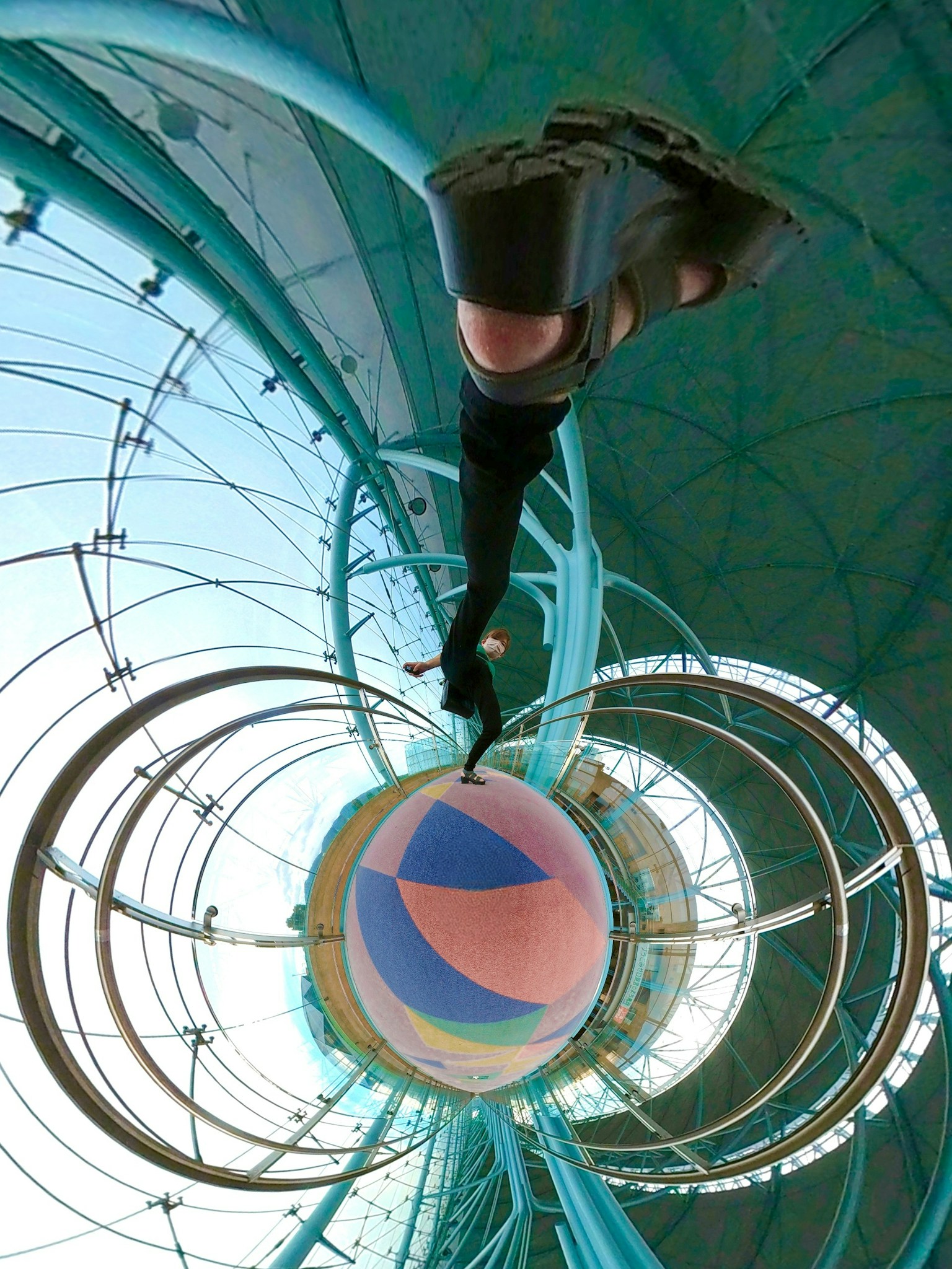 Unique perspective of a person holding a ball under a blue roof