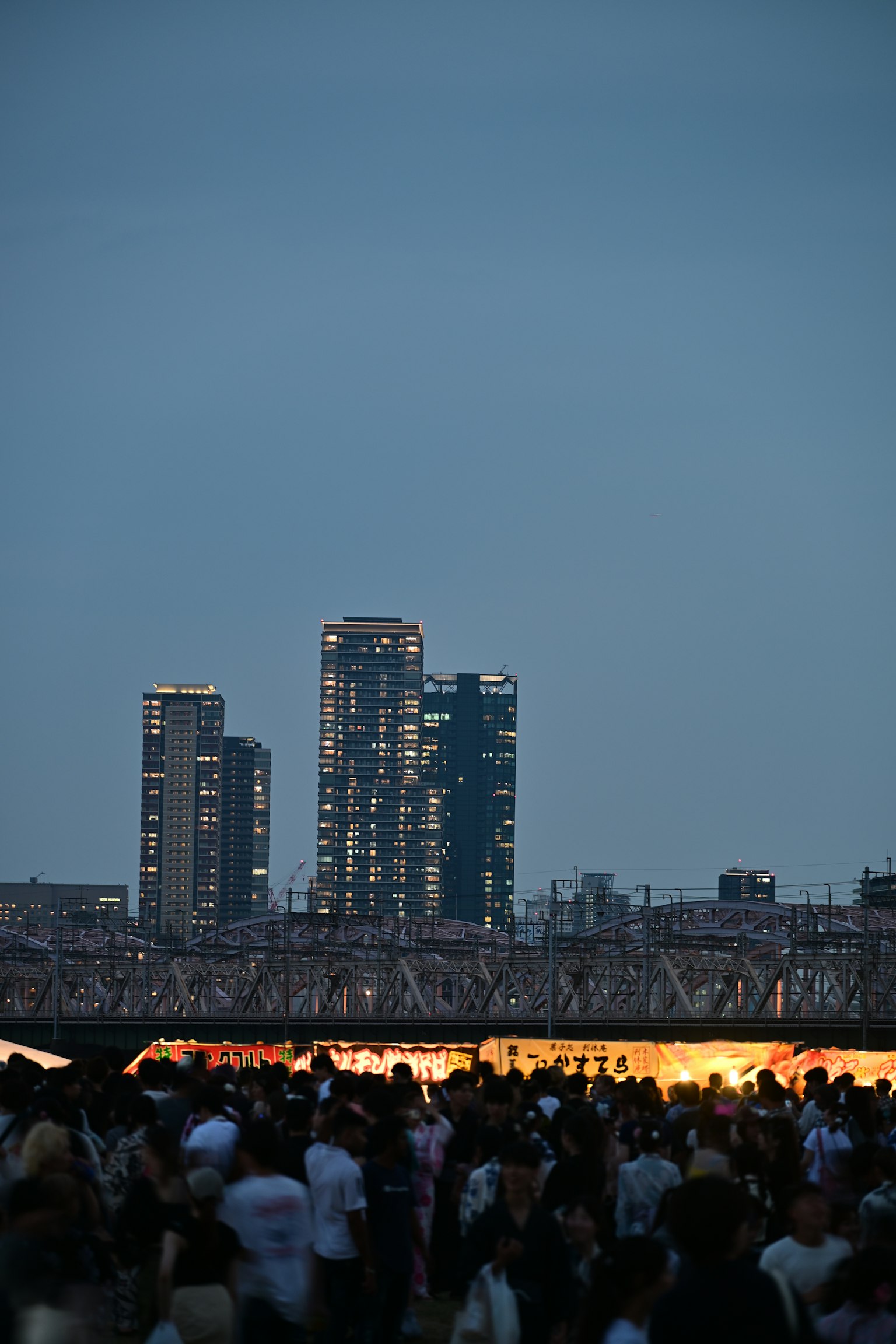 Paisaje urbano nocturno con multitud y edificios iluminados