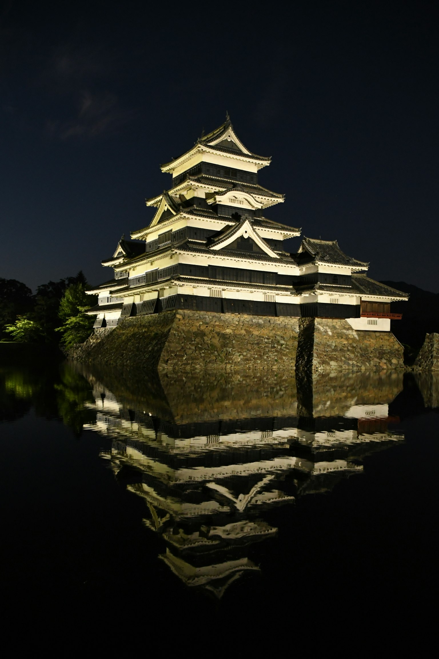 Kastil Matsumoto di malam hari dengan refleksi indah di air