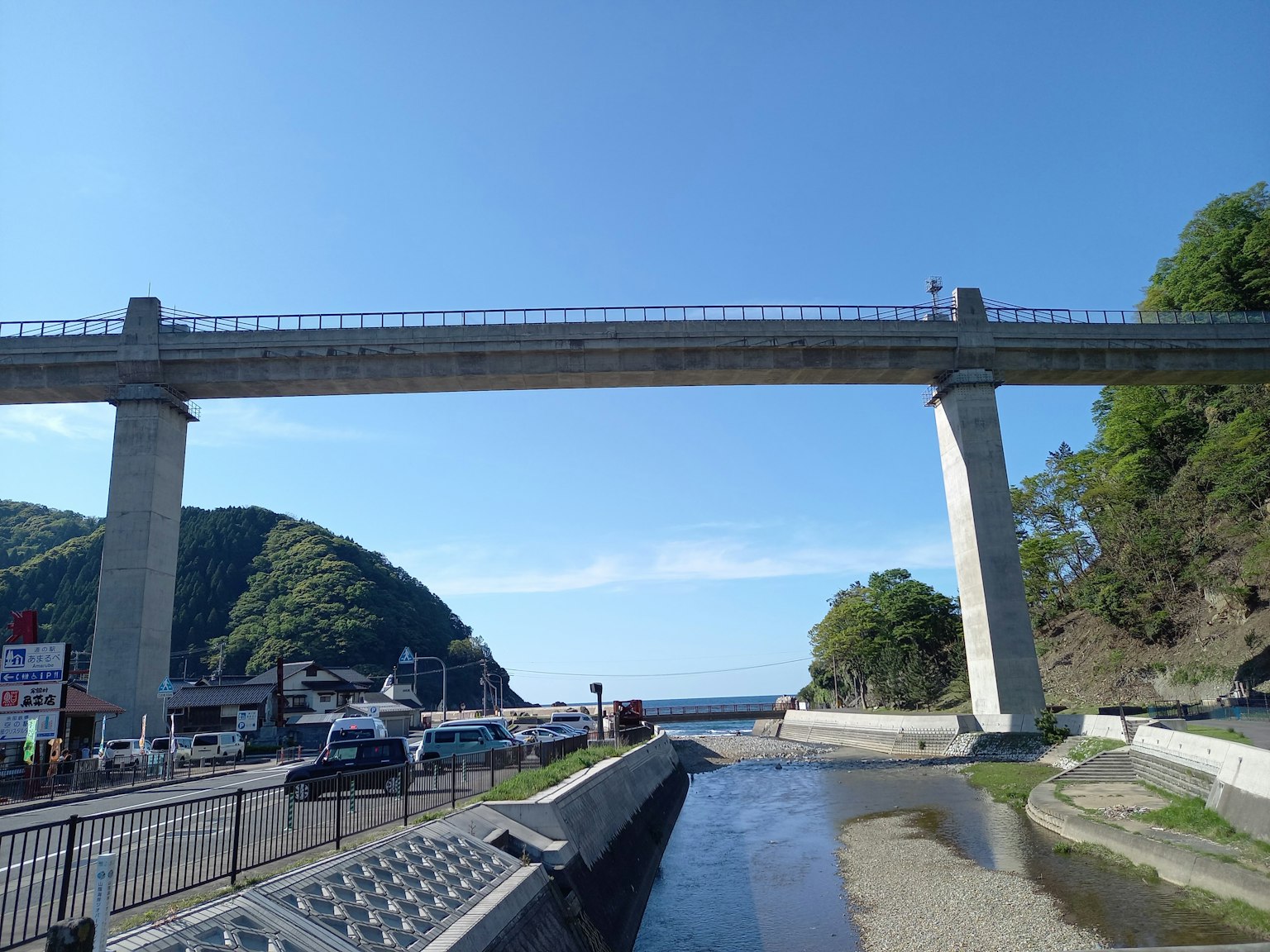 สะพานสูงใต้ท้องฟ้าสีฟ้าพร้อมทิวทัศน์ธรรมชาติรอบข้าง