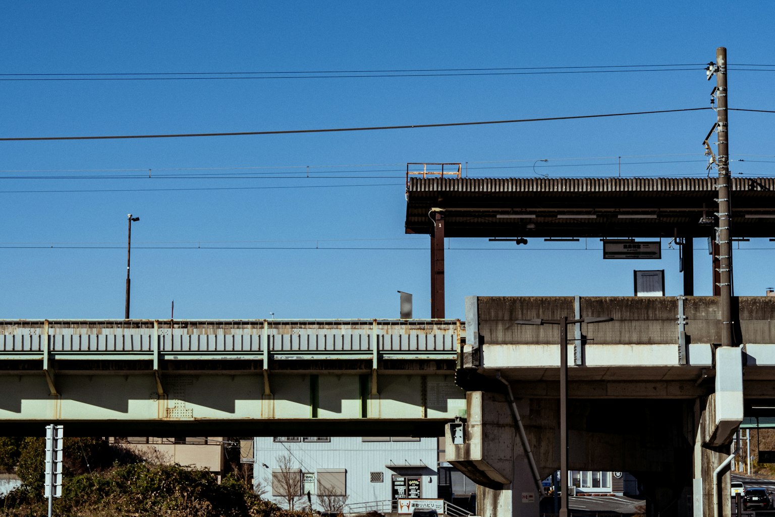 Vista di un'autostrada elevata con cielo blu che presenta segnali stradali e pali elettrici