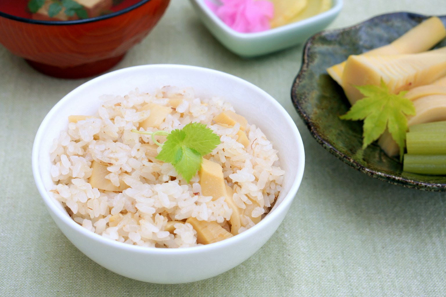 Bol de riz au bambou garni d'une feuille verte avec des plats d'accompagnement japonais