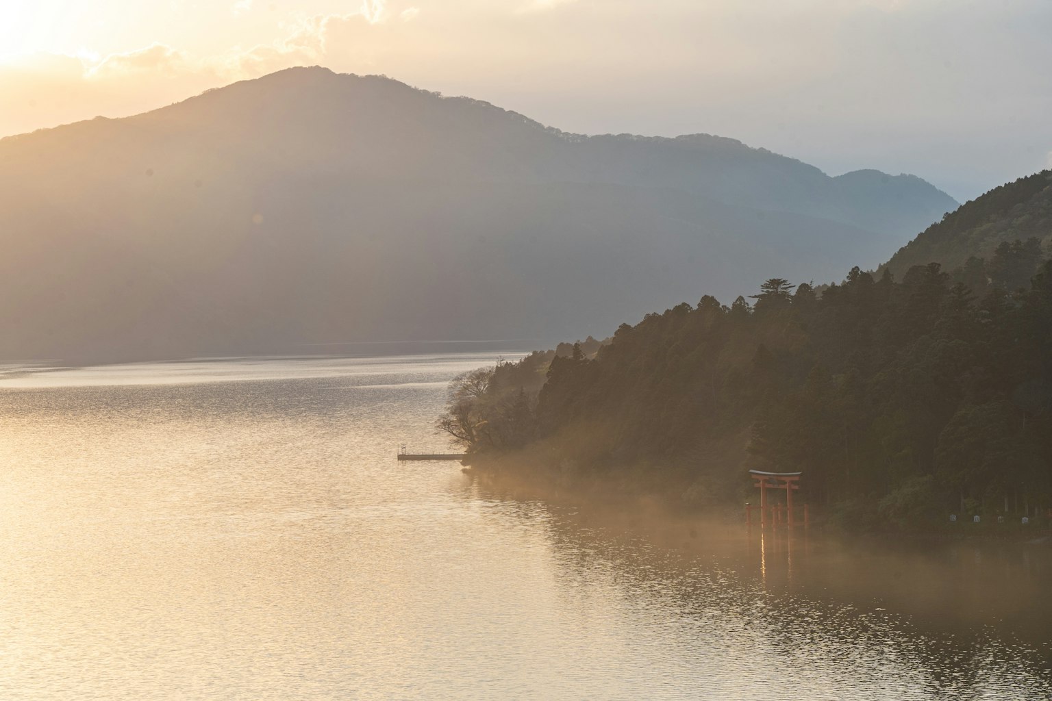 Serene landscape of a lake and mountains soft sunset reflected on calm water