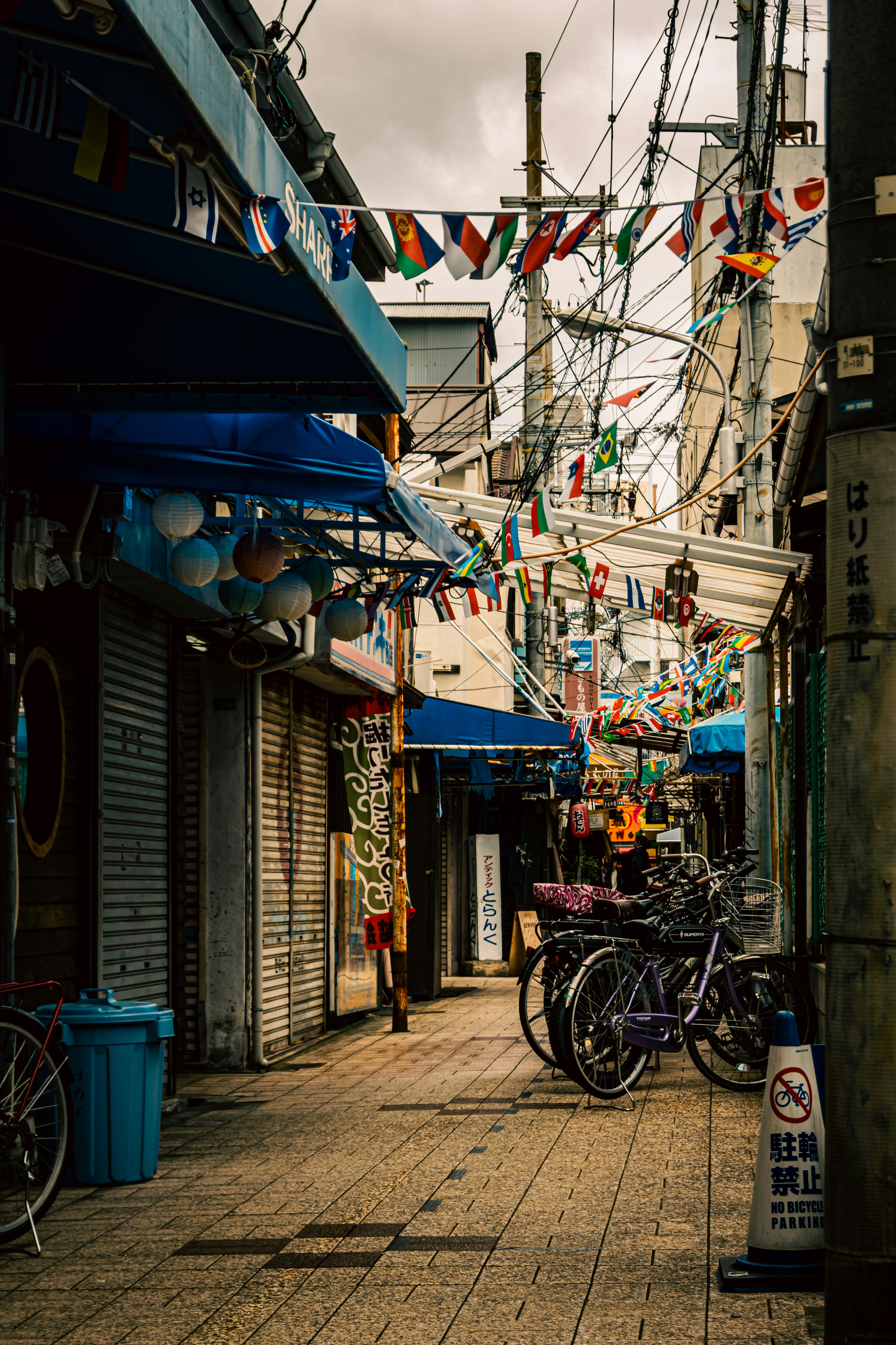 路地に並ぶ自転車と商店街の軒先の風景