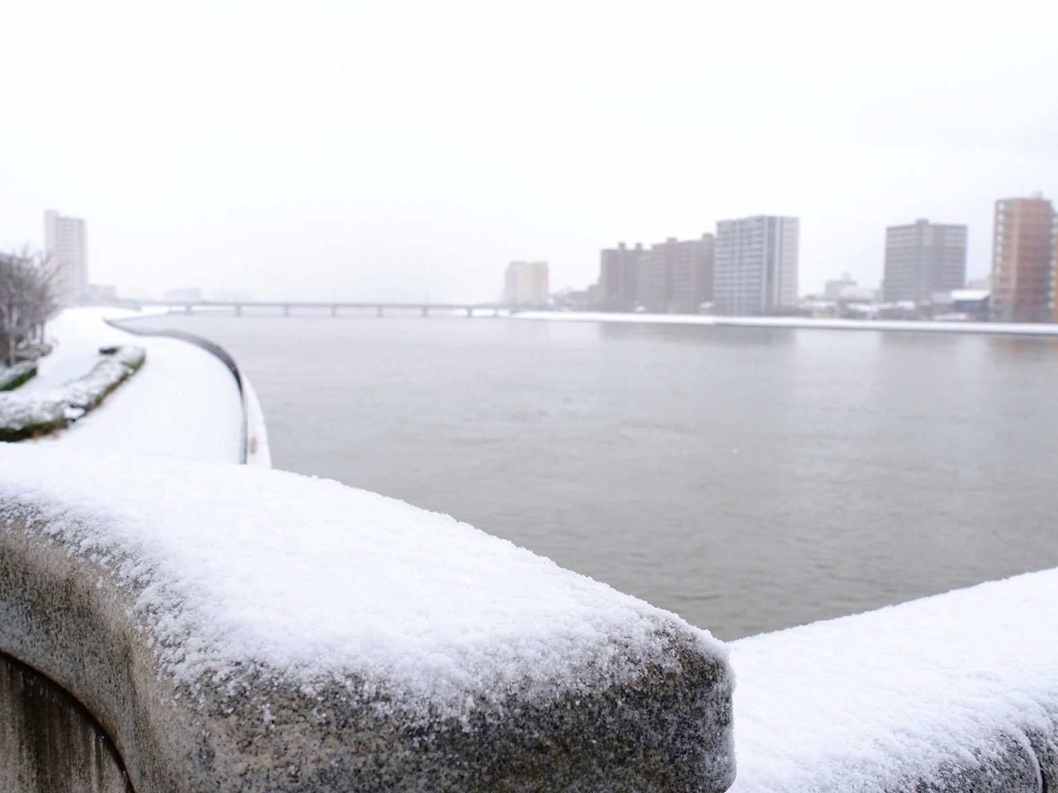 雪覆盖的河流景观，背景有建筑物