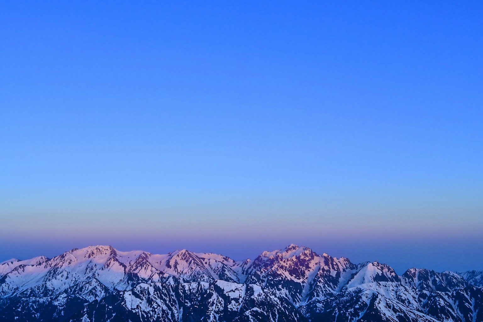 Montañas cubiertas de nieve bajo un cielo azul claro