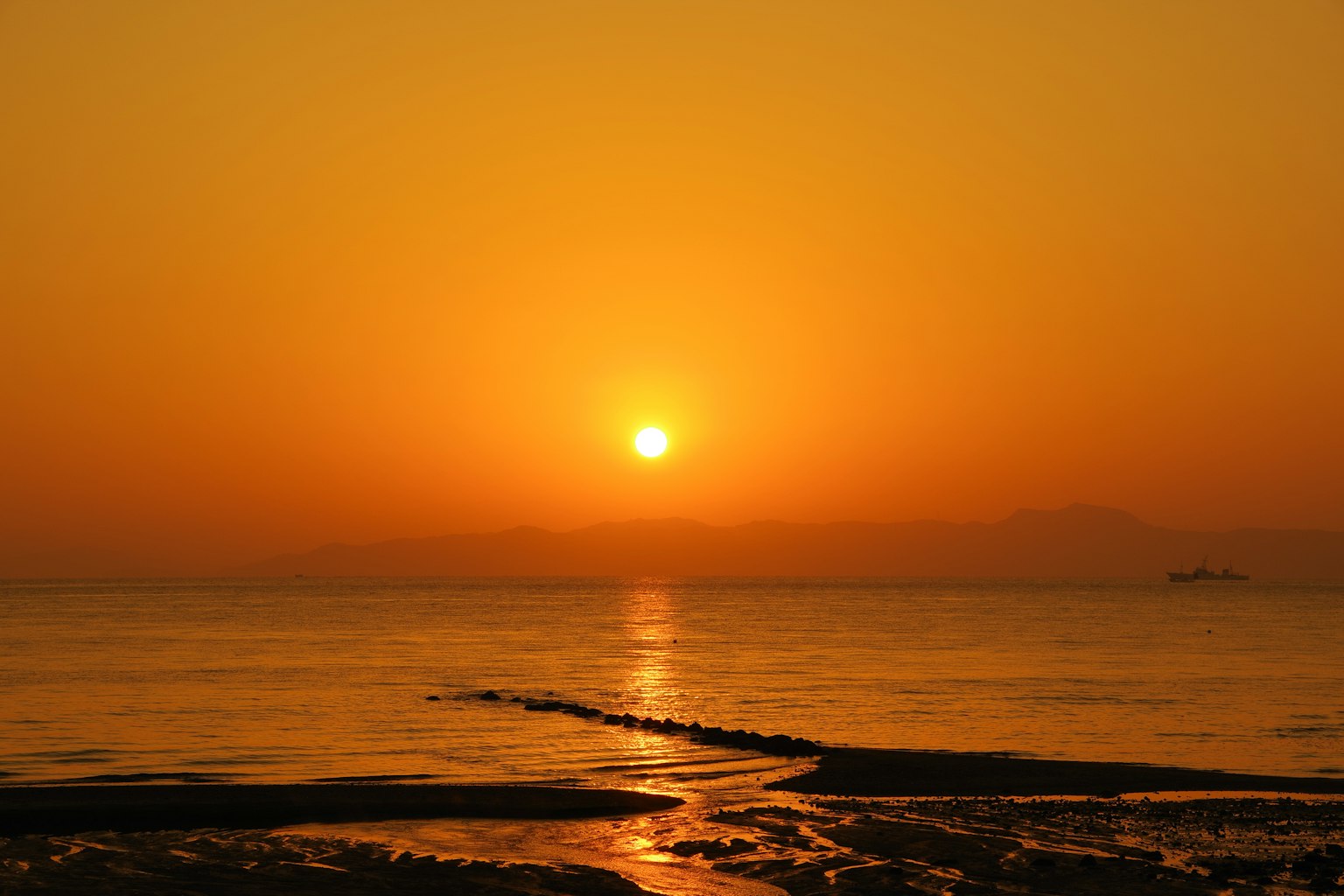 Schöner orangefarbener Sonnenuntergang über ruhigem Meer
