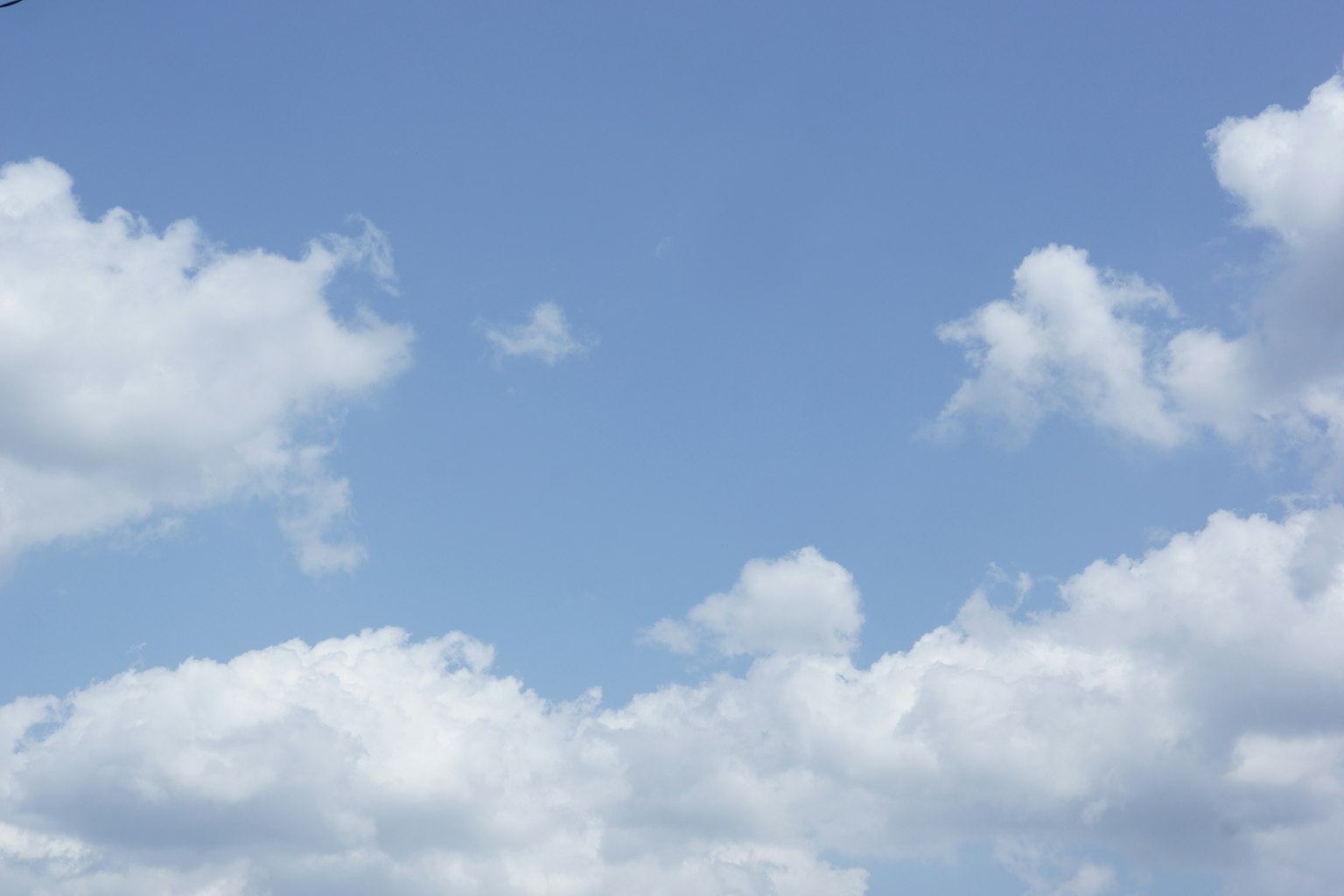 Clear blue sky with fluffy white clouds
