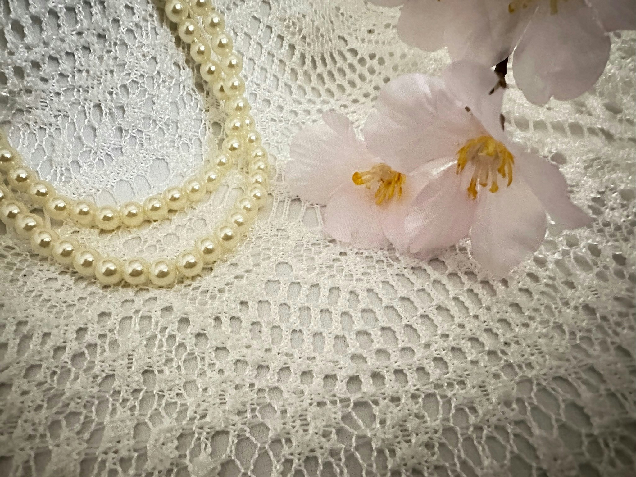 白色蕾丝布与珍珠项链及花卉点缀